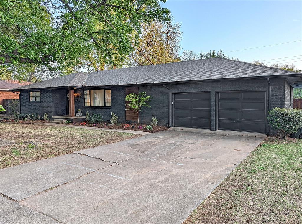 Ever wanted to live on the front page of a magazine?" Located in South Central Norman, this mid-century modern is just five minutes from OU with a striking charcoal-painted brick facade paired with warm wood slat accents and all tucked beautifully beneath a sprawling canopy of mature oak trees.Inside, natural light pours across light oak floors, highlighting a dramatic charcoal fireplace wrapped in honed marble.  An architectural wood slat wall wraps the outside of the study, introducing an organic texture that contrasts perfectly against the home's sophisticated palette.The kitchen centers around a built-in channel-tufted leather banquette and custom oval dining table. Striking quartzite countertops and a dark mosaic tile backsplash complement rich stained cabinetry, while a premium 5-burner Cafe style oven/range provides exceptional cooking capability. Storage is abundant, featuring a generously sized walk-in pantry with floor-to-ceiling wraparound shelving and just on the other side of the kitchen, a large interior laundry room offers supreme daily convenience.The primary suite is a true sanctuary. French doors open to reveal direct private access to the outdoor pool. The space includes an expansive master closet outfitted with boutique-style millwork and a center island dresser. The completely redone master bathroom is a revelation in design, showcasing custom walnut vanities, honed granite countertops, a freestanding tub, and a large frameless shower adorned with dark glazed tile. The home features three full baths total, maintaining this elevated aesthetic throughout.The backyard is designed with relaxation in mind and seamless entertaining. A covered back patio transitions fluidly into a huge open concrete sun deck surrounding the large rectangular swimming pool. Multiple seating zones and an outdoor grill station are shaded by towering trees, creating a completely private retreat.