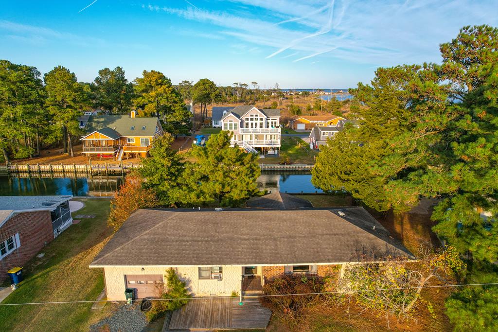 Waterfront ranch home with Oyster Bay views! This one-level property sits on over a quarter acre and offers 3 bedrooms, 2 baths, plus a valuable bonus room perfect for extra living space, office, or guests. Features include a large screened porch, attached garage, laundry room, and a kitchen that opens to the dining area. Located on a canal-front lot in an established neighborhood. Priced low to allow the new owner to update and make it their own—excellent potential and a great waterfront buy!