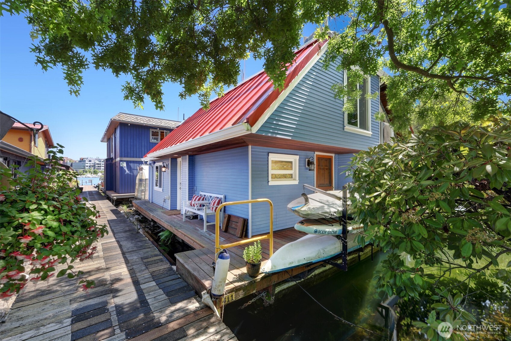 Eleven floating homes reside here at Houseboat Harbor in Portage Bay, but only one is as memorable as this home.  Maybe it's the memorizing wildlife witnessed daily on your lake retreat. The heron fishing below, the eagle nesting above. Or maybe it's the stillness in the morning as you launch the kayak for the morning exercise routine. You'll appreciate the two bedrooms, and two bathrooms covering 1,000 square feet in a great flow floor plan.  The live edge bar is a cool place to work from home overlooking the natural setting outside.  Inside are hardwood floors, a lovely wood burning fireplace, and excellent natural light from the windows and skylights.  Outside are 360 degree views from two roof tops and plenty of room for a hot tub. But our favorite place? It's the kitchen table, a place to gather and admire the views both inside and out. Plus fantastic custom storage under the bench seating.  Tie up your boat, park the car in your dedicated parking space, store your bikes in the onsite storage, plus a shared wood shop are more additional amenities.