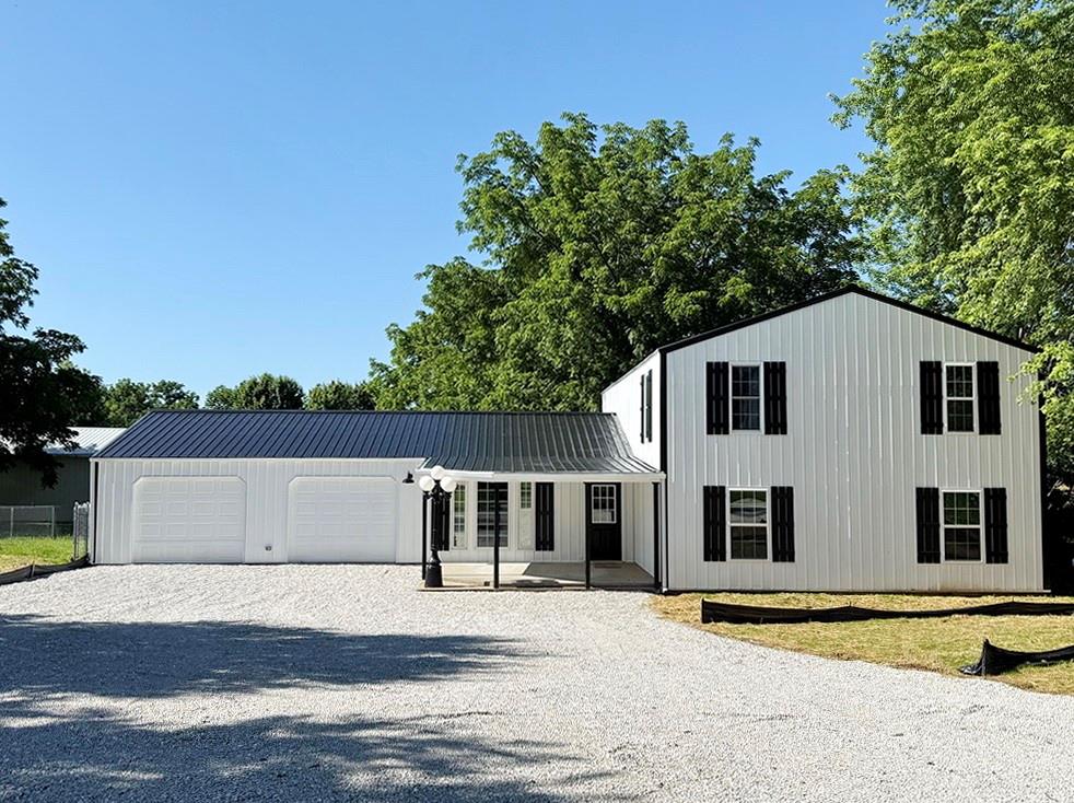Newly Renovated Home in Stockton, Missouri with Outbuilding – Located down a long driveway on the NW corner of Stockton is this 4-bed, 2-bath contemporary home that has just experienced a complete update.  With the home set back from the road, you will get a sense of seclusion with the amenities of living on the edge of town. The exterior of the home is sleek and stylish with the white-black contrast and accents.  The outdoor experience on this property is amazing with nice outbuilding, large yard, 14’x17’ covered front porch, and the 14’x40’ covered back patio surrounded by a fenced-in yard. The exterior is sharp and inviting.  The inside of the home boasts a large kitchen with solid oak cabinetry and new countertops. There is plenty of space on the main level with 2 bedrooms, 1 bathroom/utility room, a living room, bonus room, tons of closet space, and access to the 25’x25’, 2-car attached garage (with built-in shelving storage). The upstairs is just as roomy with 2 more bedrooms, a living room, and a full bathroom with a large vanity.  The upstairs not short on closet storage either.  You could have the master bedroom be upstairs or downstairs, as large bedrooms exist in both locations. Come and experience the quality of life close to Stockon Lake in a quaint, rural community where the pace of life is a little slower, and the air is a little fresher.  Located just 2 miles from boat ramps, beaches, and marinas, this property checks a lot of your boxes.