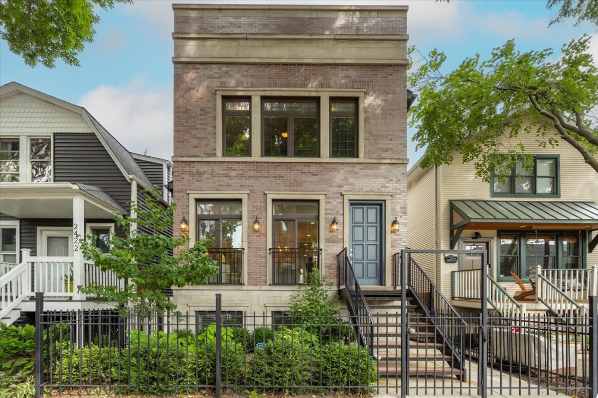 Step into the elegance of 2418 West Pensacola Avenue, a beautifully maintained home built in 2015 and lovingly cared for by a single family over the past decade. Nestled in a quiet pocket of the vibrant North Center/Lincoln Square neighborhood, this residence offers 3,600 square feet of thoughtfully designed living space-perfect for comfortable everyday living and stylish entertaining. The formal living and dining room is bathed in southern light, thanks to dramatic floor-to-ceiling windows, creating a welcoming and sophisticated first impression. A butler's pantry and wet bar with a separate beverage fridge connect this space to the kitchen, adding both functionality and elegance-ideal for entertaining. At the heart of the home is the chef-inspired kitchen, equipped with a high-end stainless steel appliance package including a Bosch refrigerator, Thermador six-burner range with pot-filler, and built-in drawer microwave. The oversized island, finished with mitered quartz countertops, provides ample prep space and casual seating for four. A cozy breakfast nook allows room for a kitchen table-perfect for meals, homework, or morning coffee. Flowing seamlessly from the kitchen is the spacious family room, anchored by a gas fireplace, offering a warm and inviting place to unwind. Just beyond, step out to the main-floor deck, ideal for grilling and al fresco dining. The turfed backyard leads to a garage rooftop deck, creating a private outdoor oasis for relaxing or entertaining.  Throughout the home, you'll find gorgeous millwork and rich walnut-stained hardwood floors that elevate the overall aesthetic. A stylish powder room adds convenience to the main level. Upstairs, there are three generously sized bedrooms, all featuring custom closets. The primary suite is a tranquil retreat, complete with a luxurious marble bathroom offering a double vanity and a walk-in double steam shower. A full-size washer and dryer are also conveniently located on this level. The lower level offers flexible living options, with a large recreation room featuring built-ins and a wet bar, a fourth bedroom, full bathroom, and second laundry hookup-ideal for guests, a home office, or extended family. Dual Zoned HVAC. Located just a short stroll from Horner Park, the Chicago River, and Welles Park, you're also moments from neighborhood favorites like Jimmy's Pizza Cafe, The Warbler, the Old Town School of Folk Music, and the beloved Lincoln Square Farmers Market-just a few of the many highlights that make this community truly special.