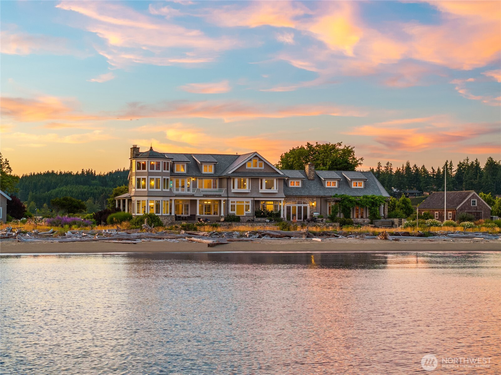 Discover a landmark estate—one of the Pacific Northwest’s truly iconic coastal homes—set on one of Washington's most beloved beaches. Bathed in golden southern light and framed by postcard views of Mt. Rainier, this coastal sanctuary is a Robert Maloney original—an architectural love letter to the Hamptons, steeped in East Coast style and grounded in Northwest sensibility. Thanks to the unique geography of Useless Bay, the home opens to 224' of pristine low-bank waterfront with nearly 1,000' of sugar sand beach at low tide scattered with sand dollars. Designed as a place for generations to gather and unwind, the property is privately tucked within a gated enclave of four estates and located just 10 mins from Useless Bay Golf & Country Club.
