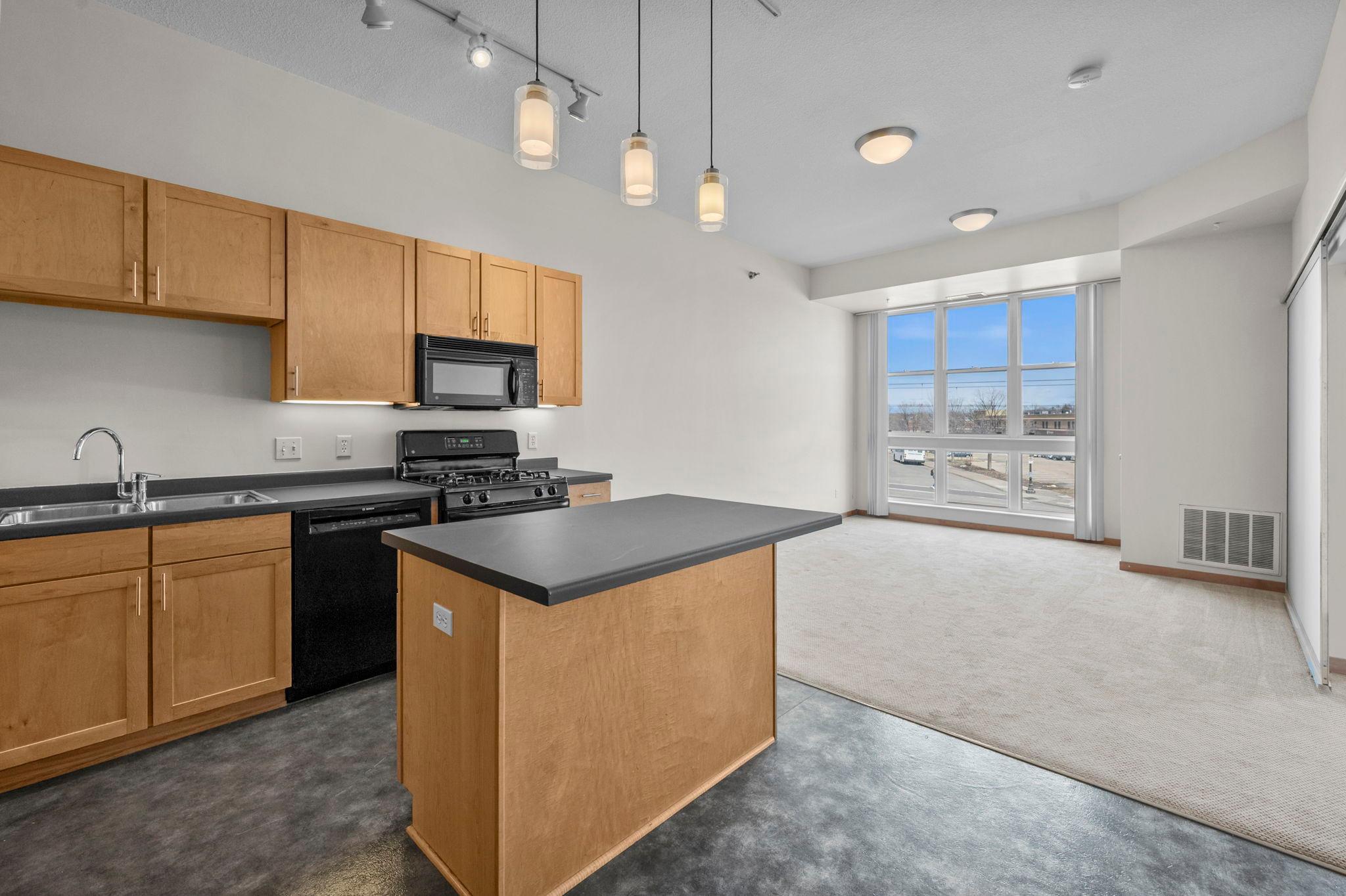 Spacious, open 2-bedroom, 1-bathroom condo in a prime, highly convenient St. Paul location. Ideally situated between Minneapolis and St. Paul, this home offers exceptional access to the best of the Twin Cities. Just minutes from Highway 280 and steps from the Green Line Light Rail’s Westgate Station, commuting is quick and easy in any direction.A neighborhood grocery store sits right outside the building, while the Mississippi River, nearby parks, and a variety of shops, cafes, and dining options are all close by, offering the perfect blend of urban energy and everyday convenience.Inside, 10-ft ceilings and large windows create a bright, airy feel throughout the open-concept layout. The spacious kitchen features abundant cabinetry, a center island with breakfast bar seating, and stylish pendant lighting, ideal for both daily living and entertaining. The kitchen flows seamlessly into the dining and living area.The primary bedroom is generously sized with great natural light, a sleek sliding door, and a large walk-in closet. The walk-through full bathroom includes a tub/shower combo and ample vanity storage space. A second bedroom offers flexibility for guests, a home office, or additional living space.Additional highlights include in-unit laundry, extra storage, a heated garage parking space, and rental-friendly policies with no waiting period.