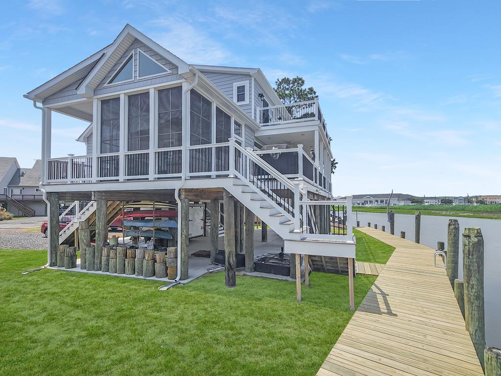 GOING LIVE JULY 4TH. This four-bedroom, two full and two half bathroom home offers 2,304 square ft of thoughtfully designed living space, nestled along a scenic canal with stunning, bay views. Whether you're searching for a year-round residence or a weekend haven, you'll find comfort and style in every corner.Step into a spacious kitchen featuring a large island, beveled-edge countertops, and modern finishes that make cooking a joy—not a chore. The open-concept layout includes a cozy upstairs living area with a convenient kitchenette, perfect for guests or all-day snack breaks.Enjoy year-round sunshine in the four-season room with telescopic windows that bring in the beauty of the outdoors without the bugs. Large decks finished with low-maintenance composite decking.
