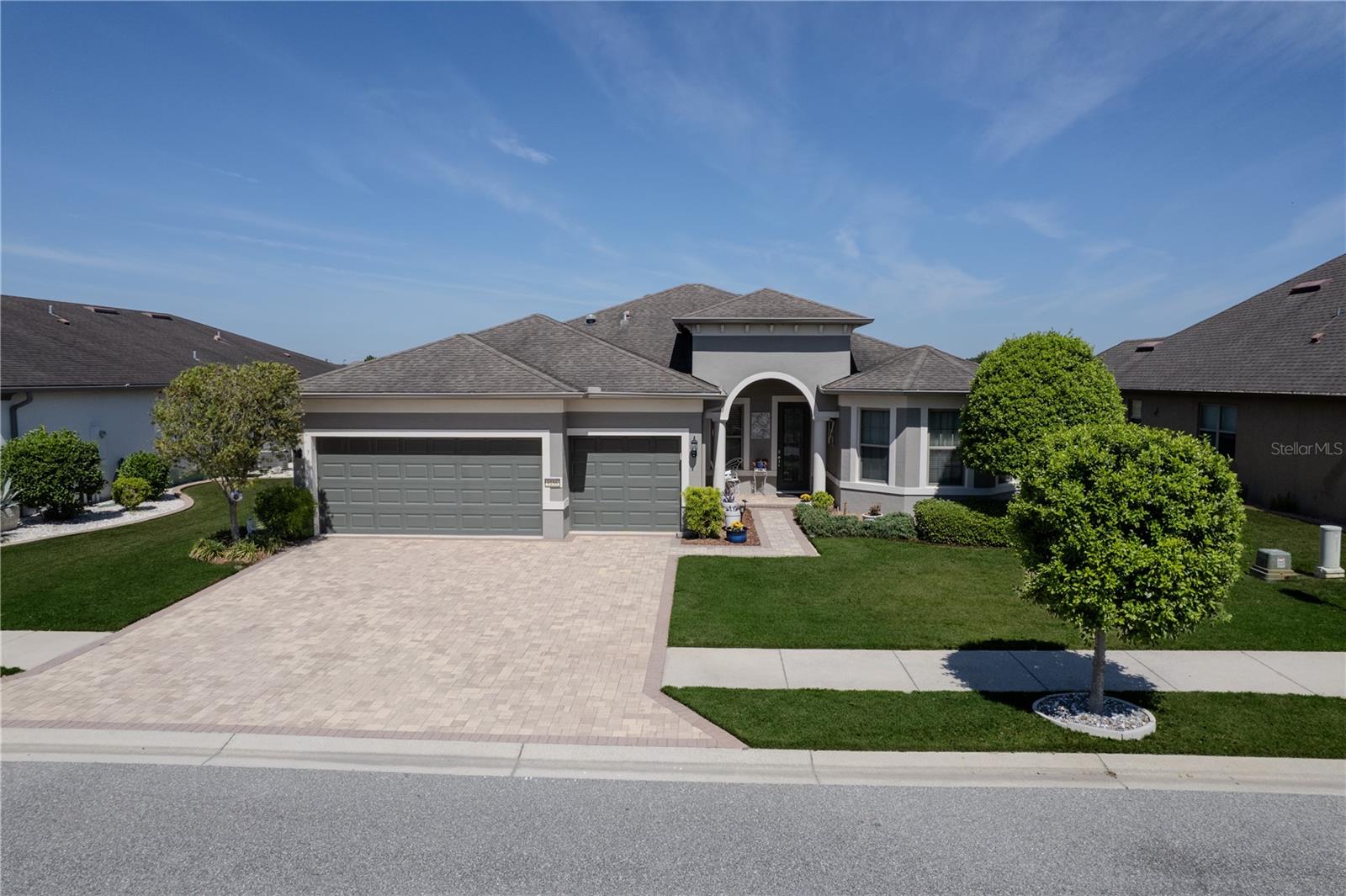 Experience refined Florida living in this stunning Pinnacle model home perfectly positioned on the lake in Del Webb Stone Creek, where thoughtful design meets breathtaking water views.From the moment you arrive, the paver driveway and elegant entryway set the tone for what awaits inside. Step through the front door and you’re immediately welcomed by an open, airy layout designed for both everyday comfort and effortless entertaining. Just off the foyer, glass French doors lead into a versatile flex room, ideal for a home office, hobby space, or guest retreat.At the heart of the home, the gourmet kitchen is a true showstopper, featuring granite countertops, upgraded cabinetry, and ample prep space, all seamlessly flowing into the spacious gathering room and dining area. Whether hosting friends or enjoying a quiet evening in, this open-concept design keeps everyone connected.The real highlight? Zero-corner sliding glass doors that completely open the home to the outdoors—creating a seamless transition to your paver screened lanai overlooking the serene, sunlit lake. This is Florida living at its finest, offering the perfect setting for morning coffee, evening sunsets, and year-round indoor-outdoor enjoyment.The primary suite is a private retreat, enhanced by a tray ceiling and tranquil views. The en-suite bath features a beautifully tiled walk-in shower, dual vanities, and a spacious layout designed for relaxation. Guests will feel equally comfortable with two additional bathrooms, each featuring tiled showers for a clean, upscale finish.Additional highlights include a well-appointed laundry room with utility sink, quality finishes throughout, and a layout that balances privacy with open living spaces.Beyond the home, enjoy everything that makes Del Webb Stone Creek one of Ocala’s most sought-after 55+ communities. Residents have access to resort-style amenities including multiple clubhouses, indoor and outdoor pools, a full-service fitness center, spa, and an on-site restaurant.Stay active with pickleball, tennis, bocce, softball, and miles of walking trails, or tee off on the private 18-hole championship golf course.A full-time lifestyle director coordinates clubs, events, and social activities, creating a vibrant, connected community where every day offers something new.This is more than just a home—it’s a lifestyle. Come experience lakefront living, elevated design, and resort-style amenities all in one exceptional property.