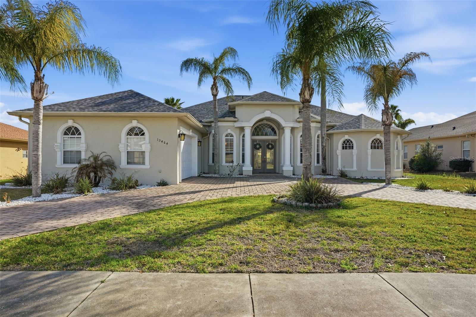 Florida living at its best in the gated community of Pristine Place. This Lexington “Caravelle” model offers 3,183 sq ft with 4 bedrooms + office, 3 bathrooms, and a 3-car garage on a spacious 1/3-acre lot surrounded by 17 mature palm trees and a circular driveway.Inside, the home features a bright open layout with tray ceilings, crown molding, formal dining space, and a split floor plan. The kitchen is designed for both everyday living and entertaining with leathered granite countertops, a large island, granite breakfast bar, stainless steel appliances including a counter-depth refrigerator, cooktop with convection oven, extra-deep sink, 42” cabinets, pantry, and plenty of storage.The owner’s suite includes two walk-in closets and a spacious bathroom with a garden tub, dual vanities, makeup vanity, and private water closet. The 21x16 fourth bedroom offers flexibility and could easily serve as a bonus room, guest suite, theater room, or pool cabana.The backyard is built for relaxing and entertaining. The heated pool was resurfaced in 2021 and features a spillover waterfall and travertine pavers. In 2023 the owners added a full outdoor kitchen with a large island and barstool seating, charbroiler, 48” flat top grill, and commercial fryer. Retractable screens open to additional paver space, making it the perfect spot for a fire pit or outdoor gathering area.Major updates include roof replaced in 2021, both AC systems replaced in 2020, and an irrigation well for the lawn. HOA fee of $230/quarter includes access to a clubhouse, fitness center, community pool, playground & tennis courts.Located just 5 minutes from the Suncoast Parkway, Target, and Starbucks, and directly across the street from Pristine Place you'll find Publix, Walmart Neighborhood Market, Walgreens, Rookies Sports Bar & Grill, and Tidal Brewing Co.