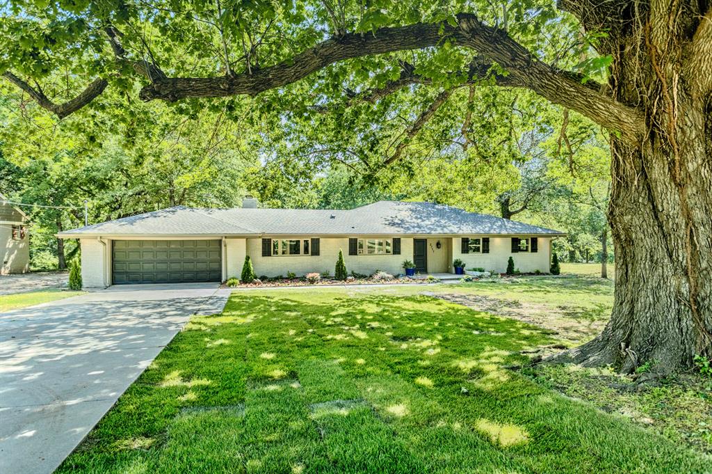 Stunning and move-in ready, this beautifully remodeled home combines quality craftsmanship, thoughtful updates, and a peaceful setting just five minutes from the University of Oklahoma campus. Extensively remodeled from top to bottom in 2024 by local builder Barry Law, the home features a new roof (2024), new wood flooring throughout, stylish new light fixtures, and fresh interior and exterior paint. Step inside to a spacious, light-filled living area where large windows frame tranquil views of the wooded creek beyond the backyard, creating a beautiful backdrop for quiet mornings and entertaining alike. An oversized utility room adds both charm and functionality, while the home's position set well back from the road provides ample parking, a generous front yard, and a picturesque mature tree.Notable upgrades include a whole-home Generac generator for added peace of mind and a dedicated EV charging station in the garage. Thoughtfully updated for modern living while maintaining timeless appeal, this exceptional home offers the rare combination of convenience, comfort, and a serene natural setting -- all just minutes from OU.