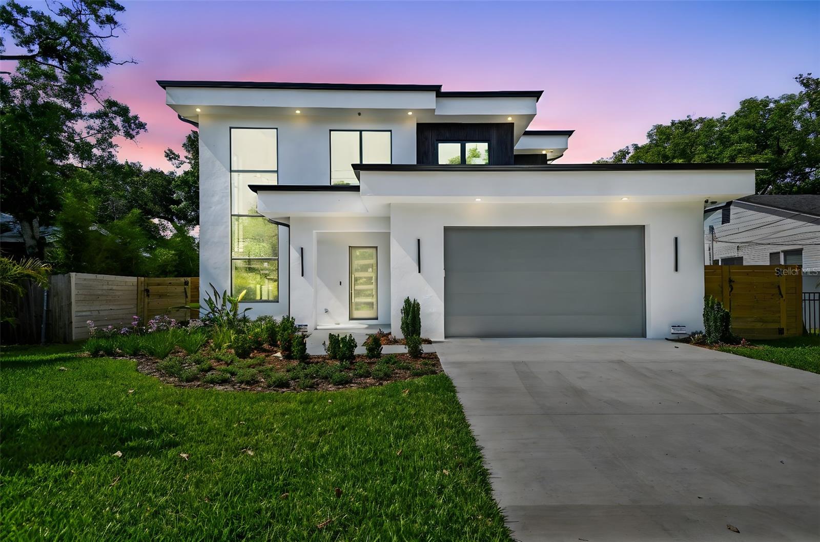 Luxury living in the heart of Riverside Heights! This sleek, modern, new-construction masterpiece is move-in ready and thoughtfully designed with every upgrade imaginable. From the moment you step inside, you’re greeted by a spacious, open dining room bathed in natural light streaming through oversized, vertical windows. The gourmet kitchen is a chef’s dream, boasting quartz countertops, GE Café Collection appliances, double kitchen islands with ample storage, a glass cleaner faucet, a 6-burner gas range, and built-in double convection ovens, one with French doors.
The family room includes a gas fireplace, perfect for cozy evenings, and opens via sliders to a covered lanai and a stunning marble pool deck, ideal for entertaining by the heated saltwater pool and spa. A stylish, glass-enclosed wine room, with capacity for 270 bottles, serves as a chic accent to the living space. The first floor features two large bedrooms sharing a Jack-and-Jill bathroom, complemented by color-drenched paint, 24” x 48” tile floors, and a level 4 drywall finish for a polished look.
Ascend the floating staircase with a modern black iron rail to discover light-colored engineered hardwood floors and a versatile loft with a wet bar, ice maker, and beverage refrigerator. The primary suite is a true retreat, featuring an oversized balcony overlooking the pool. You’ll feel like you’re on vacation every day! The spa-inspired primary bath includes floating cabinets with underlighting, a freestanding tub, and an oversized shower with three shower heads. The primary walk-in closet is a masterpiece of organization, with built-ins, an island, and direct access to the laundry room.
Additional highlights include 10’ ceilings, 8’ interior doors, solid wood shelving in all closets, a tankless gas water heater, and an oversized garage designed to comfortably fit two cars. The home is pre-plumbed for a whole-house generator, a gas fire pit, and an outdoor kitchen, offering endless possibilities for customization.
Nestled in Tampa’s historic Riverside Heights, this home is at the heart of a vibrant, redeveloped urban community just minutes from Downtown Tampa. Enjoy unparalleled access to local gems like Armature Works, Water Works Park, trendy craft breweries, and acclaimed restaurants. Three nearby city parks provide direct access to the Hillsborough River for kayaking, paddleboarding, and more. With the Tampa Riverwalk extension and proximity to cultural hubs like the Straz Center and Amalie Arena, this location blends serene residential charm with the pulse of urban living.
This is more than a home—it’s a lifestyle. Don’t miss your chance to own a piece of Riverside Heights’ renaissance in this meticulously crafted residence.