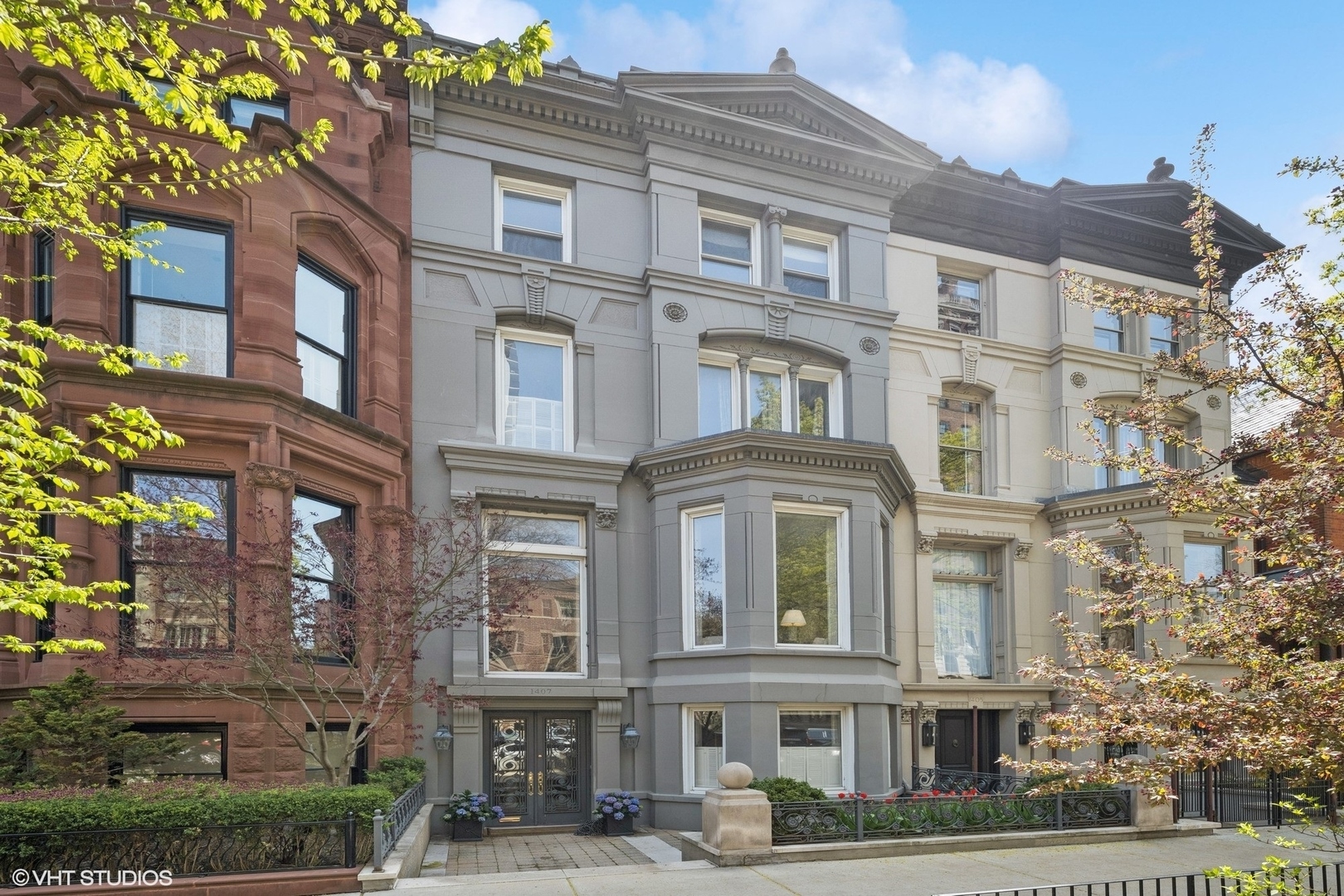 Historic Gold Coast Row Home on Extra-Deep Lot with Rare Garden Oasis and 2-Car Garage! Perfectly positioned on a quiet, tree-lined block in Chicago's prestigious Gold Coast, this stately row home sits on an exceptional 25' x 132' lot-offering a rare combination of historic charm, expansive indoor-outdoor living, and coveted parking. A beautifully landscaped, oversized garden and a rare 2-car garage elevate this residence into something truly special. Behind the timeless facade, you'll find a home filled with character and light. Soaring ceilings, tall windows, and intricate moldings define the space. Floor-to-ceiling French doors open into a bright marble entryway that welcomes you home with elegance. The ground level features a sunlit family room with a bay window, a full wet bar, a spacious laundry room, and a guest bedroom with ensuite bath and direct access to the garden, ideal for visitors or multigenerational living. Up the main staircase, a charming music nook is the perfect place for a baby grand piano or reading lounge. The formal living room flows into a gracious dining room, while a thoughtfully designed butler's pantry connects to the eat-in kitchen with stainless steel appliances and generous cabinetry. A powder room completes this level. The entire third level offers 3 bedrooms, including the primary suite.  The fourth floor offers four well-proportioned bedrooms and a full bath, providing flexible space for family and guests. Located just steps from the Latin School, the lakefront, Lincoln Park, Oak Street Beach, and the city's premier shopping and dining, this home offers a rare opportunity to enjoy refined living, generous outdoor space, and timeless architecture in one of Chicago's most sought-after neighborhoods.