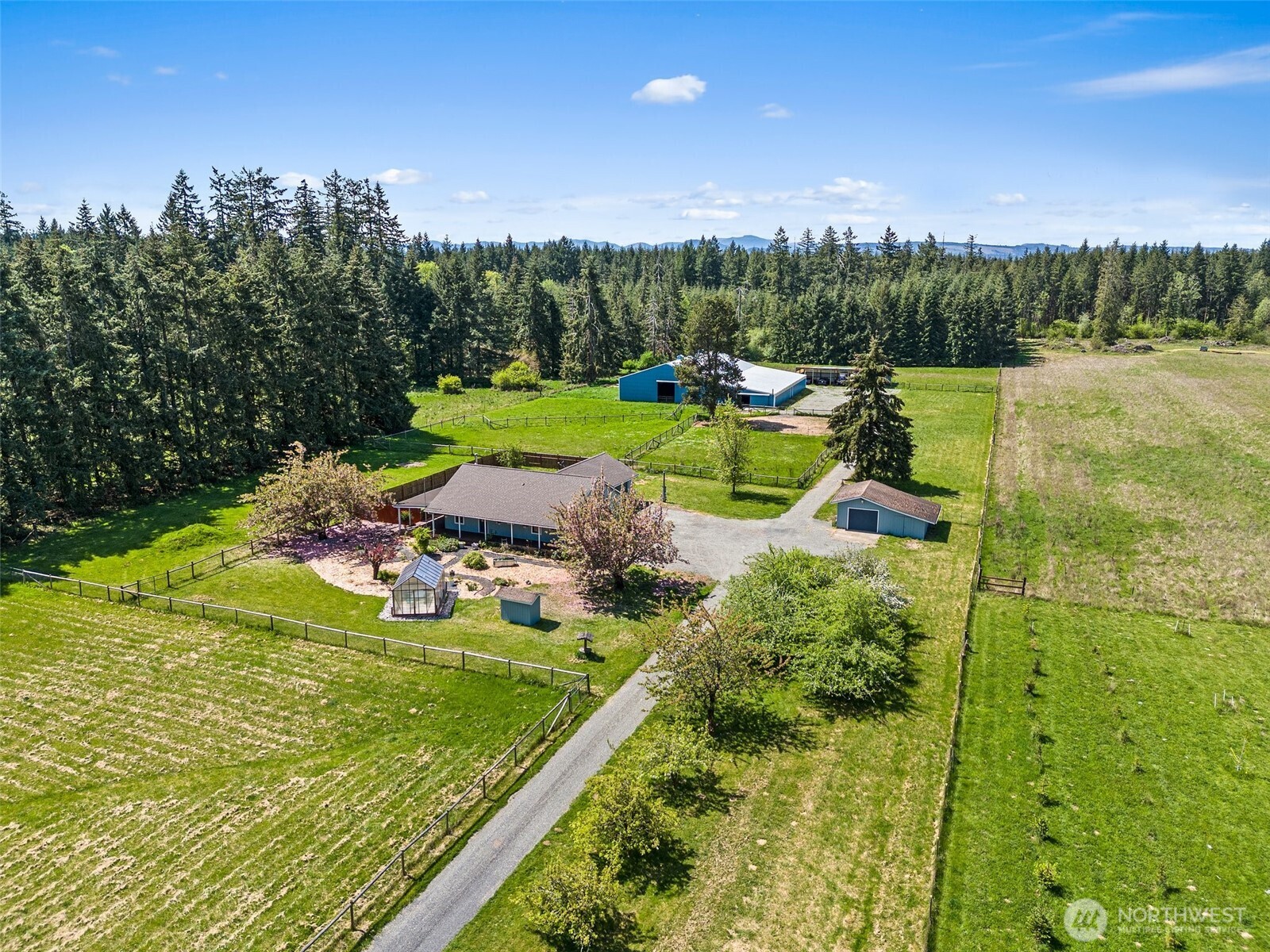Premier equestrian estate offering a blend of modern living & EXCEPTIONAL horse facilities. Situated on 5.31 FLAT acres. Cute & Quaint home w/ 3 beds, 2 baths, Sun room, open concept living, wood stove, vaulted ceilings, kitchen w/ newer appliances, tons of natural light. The property boasts a PRISTINE 60x100 INDOOR RIDING ARENA w/ updated gravel/sand/rubber footing, 10 stalls, 2 heated wash racks, a tack room COMPLETELY MOVE-IN READY! 5-bay shed for Trailers/Trucks/Boats. 5 Pastures, 2 paddocks, 10X16 Greenhouse, Fruit Trees & X-fenced w/no climb & top rails. Other amenities include a shop, woodshed, RV hookup, & access to 20 acres of logging timber for riding. Recent upgrades totaling $150,000 making it a turn-key for equestrian lovers.