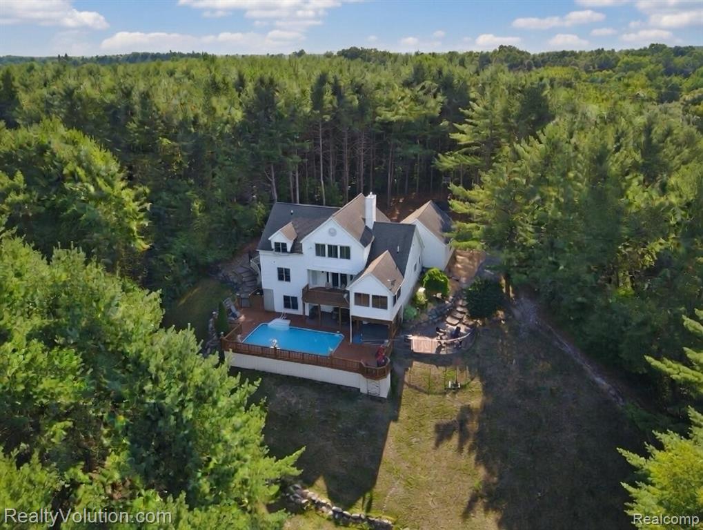 Rare opportunity awaits you on this one of a kind home and setting. Total seclusion is yours with this custom built home on 26+ acres. Tastefully remodeled within the last few years and updated for modern living.  You will love living here so you can vacation at home with private wooded trails back to Farmers Creek and an inground heated pool.  Open concept layout ideal for entertaining. Amazing brand new kitchen features expansive modern cabinetry, granite counters, including a large built in granite dining area with storage underneath. What a great spot for friends and family to gather. First floor laundry and large walk in pantry too.  Soaring ceilings in living room with lots of windows, hardwood floors and a 2 way fireplace. 2 bedrooms on first floor. Upstairs has master suite with new updated bath and a private enclosed porch overlooking your property. Finished walkout offers 4th bed and full bath, kitchen, bar, pool table, and living room. All appliances, patio furniture, hot tub, pool table are included--Truly turn key. Built in safe room with steel door ideal for guns or other valuables. Backyard is your oasis at home. In ground heated pool with a robotic cleaning system and hot tub. Surrounded by all new composite decking and modern aluminum railing system. Expensive decking offers several levels to enjoy the views, brick paver patios, 2 outdoor bonfire pits, etc.  Alarm system for security and a back up generator so you never lose power. Full house water filtration system, RO system at sinks and fridge. Located across the street from all sports and public Lake Nepessing.   26+ acres of wooded privacy plus 2 miles of private walking trails that span 100 acres of adjoining land via an easement. Excellent hunting property or for those who just want to be surrounded by nature and wildlife. 340 ft of road frontage offers a nice flat open spot for a future pole barn if you wish.  This property has so much to offer--come view it for yourself.