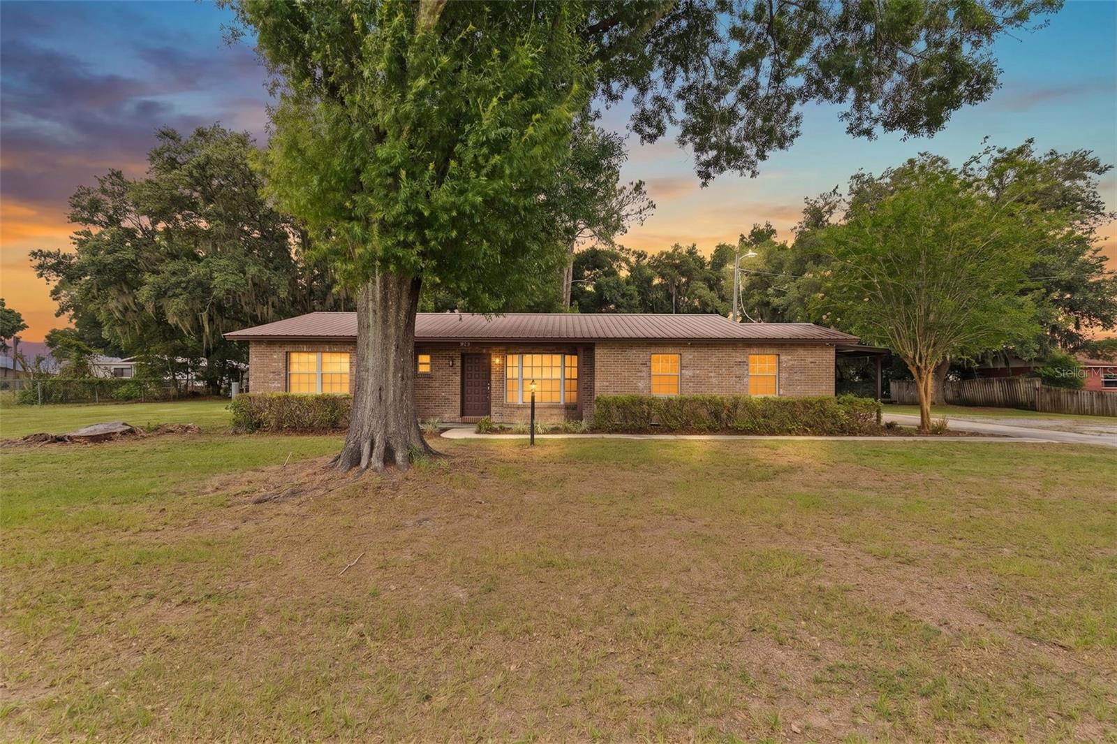 Under contract-accepting backup offers. Enjoy the freedom of country living on nearly half an acre in a peaceful and private area of Plant City with NO HOA and NO CDD fees! Situated on a fully fenced .47-acre lot, this spacious 4-bedroom, 2-bath home offers plenty of room both inside and out, making it perfect for those looking for space to spread out and store all their vehicles, equipment, recreational toys, or hobbies.Step inside to find a bright and welcoming floor plan filled with natural light, highlighted by a beautiful bay window and a large living and dining area that creates the perfect gathering space. The living room features charming built-in shelving surrounding an electric fireplace, adding warmth and character to the heart of the home.  The split-bedroom layout provides privacy for everyone. Two generously sized secondary bedrooms and a full guest bathroom are located near the front of the home, while the spacious primary suite offers an ensuite bathroom with dual sinks and a large walk-in shower. A fourth bedroom with a walk-in closet is situated near the primary suite, making it ideal for a home office, nursery, guest room, or flex space. French doors in the hallway lead to a cozy patio and back porch area where you can relax and enjoy the quiet surroundings.The kitchen features wood cabinetry, a large eat-in dining area, and easy access to the oversized one-car garage with additional storage space. Outside, you'll appreciate the metal roof, updated plumbing and electrical systems, private well and septic, chain-link fencing, carport, oversized garage, and two storage sheds.With solid updates already completed and only cosmetic touches such as flooring and paint left to personalize, this home presents an excellent opportunity to create your dream country retreat while enjoying the benefits of unrestricted living in beautiful Plant City.  One or more photo(s) have been virtually staged.