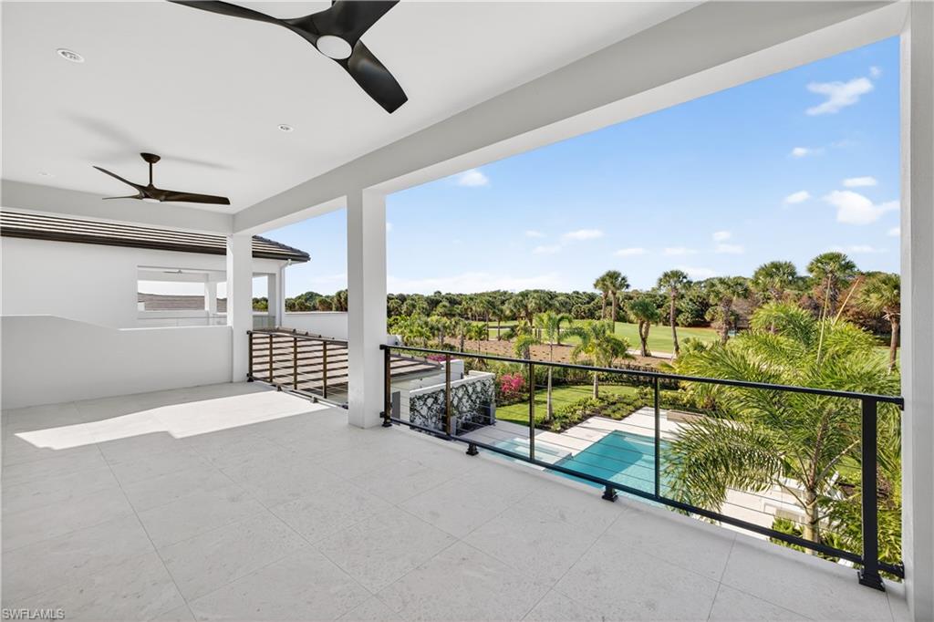 View of patio with a ceiling fan and view of scattered trees