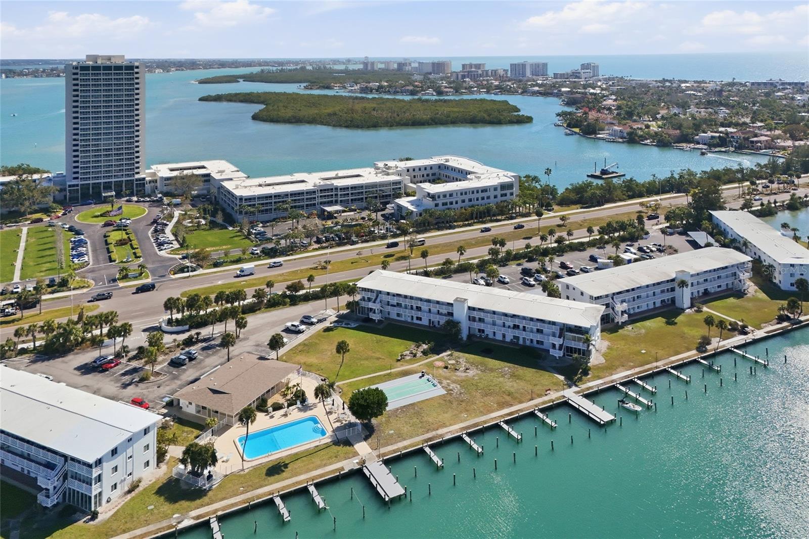 Beautiful views of Sarasota Bay await you from this 2-bedroom, 1.5-bath, second-floor condo. Newer high impact windows installed 2021.  Sarasota Harbor is a maintenance-free, 55+ community. Enjoy watching manatees and dolphins from the condo. This unit has the ultimate waterfront lifestyle that offers a leisurely walking path along the seawall, a fishing pier, swimming pool, community room, and more. Launch your kayak onto Sarasota Bay or take advantage of the available boat docks ($1,200 a year)30ft. maximum length. Perfectly positioned between the world-class destinations of St. Armand’s Circle and downtown Sarasota, you can enjoy the five-minute walk to the boutiques and restaurants that line St. Armand’s Circle or the vibrant arts, culture, shopping, and dining of downtown Sarasota across the iconic Ringling Bridge. ***Boat slips, sidewalks, and carports recently damaged from the hurricanes.