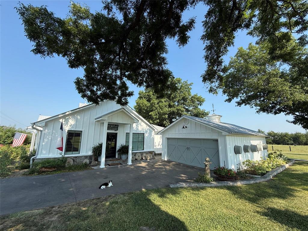 A collector's dream comes true with this farmhouse chic 2,756 square foot home, on 11-plus acres (being subdivided from a larger tract), with custom touches and tastefully hand-picked antique finishes! From the elegant 1860's Georgia wood floors and antique Chicago pavers, walk into this handsome home and be astounded by the thoughtful interior decorating that elevates the space. Barn beams from the 1840's give the vaulted ceilings a nice pop of warmth in the living room, kitchen, and dining areas. Skylights, white slat ceilings, and recessed lights also brighten up the great room. A generous kitchen includes a commercial gas range, warming tray with heat lamps, commercial vent, farm sink, dishwasher, separate ice maker by the pantry, and custom lights. The walk-in pantry comes with an antique door. The primary ensuite bedroom will impress with a spa-like bathroom that has a luxurious interior with a separate tiled shower, soaking tub, and separate double sinks. Guests will enjoy the spare bedroom with a modern hall bathroom with a tiled walk-in shower. A second living space will make the perfect family room or can be turned into a bedroom. Additional touches include custom-made Gothic window, Kohler faucets, plantation blinds from Custom Shutters, GE monogram appliances, restoration hardware vanities with solid surface Caesar Stone tops, handmade walnut doors, and handmade cupola. Sit on the oversized 1,009 square-foot deck and appreciate the mature trees that were planted in the fall of 2024. Parking is a breeze with a concrete drive and 600 square-foot garage. This house also comes with Prierfert Ponderosa fencing, spray foam in the attic and pier and beam areas, and large scenic pond. This spectacular place provides lots of curb appeal, including Copper Bevolo gas lanterns from New Orleans--all with acreage close to town. Don't let the 1940 year built fool you. The original home was re-built and 1500 feet added by a true craftsman, master carpenter!