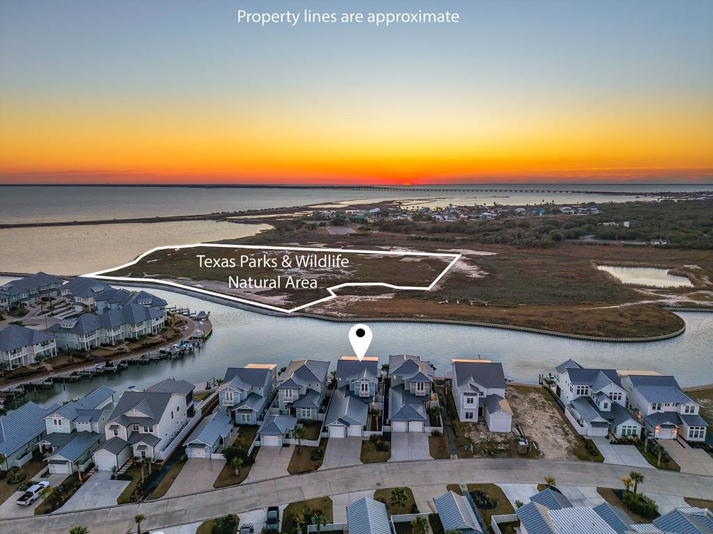 Experience exceptional coastal living at 145 Foxtail Lane, a meticulously maintained waterfront home designed to capture some of the most breathtaking views on the Texas Coast. Overlooking the protected natural beauty of Goose Island State Park, this property offers unobstructed sights and unforgettable sunsets that truly never get old. The spacious covered porch is the perfect place to relax and take it all in, while electronic roll-down shades provide comfort from the sun and added wind protection, rated for 140+ mph, so you can enjoy the space in a wide range of coastal conditions. Inside, the thoughtfully designed floor plan features 12-foot ceilings in the main living areas, an inviting living room with a gas fireplace, and an impressive kitchen with an oversized quartz island and Verona Prestige double oven gas range, ideal for entertaining. The main level includes a private guest suite with an en-suite bath, while the expansive second-floor primary suite offers a sitting area, dry bar, full wall of windows, and direct access to a covered balcony positioned to enjoy the incredible views. The spa-like primary bath features dual sinks, a freestanding tub, walk-in shower, and large walk-in closet. An additional upstairs guest bedroom features a built-in Murphy bed and desk, allowing the space to easily function as a comfortable guest room or home office. Outdoor amenities further elevate the property with a saltwater pool and gas heater, outdoor kitchen, natural gas fire pit, and a composite dock with boat lift ready for days on the water. Additional highlights include a two-car garage with epoxy flooring and climate-controlled tackle room, whole-home Generac generator, tankless water heater with water softener and dechlorinator, reverse osmosis system, hurricane shutters, and elevator prep. This is a rare opportunity to own a truly special coastal property where thoughtful design, exceptional features, and unmatched views come together in one remarkable home.