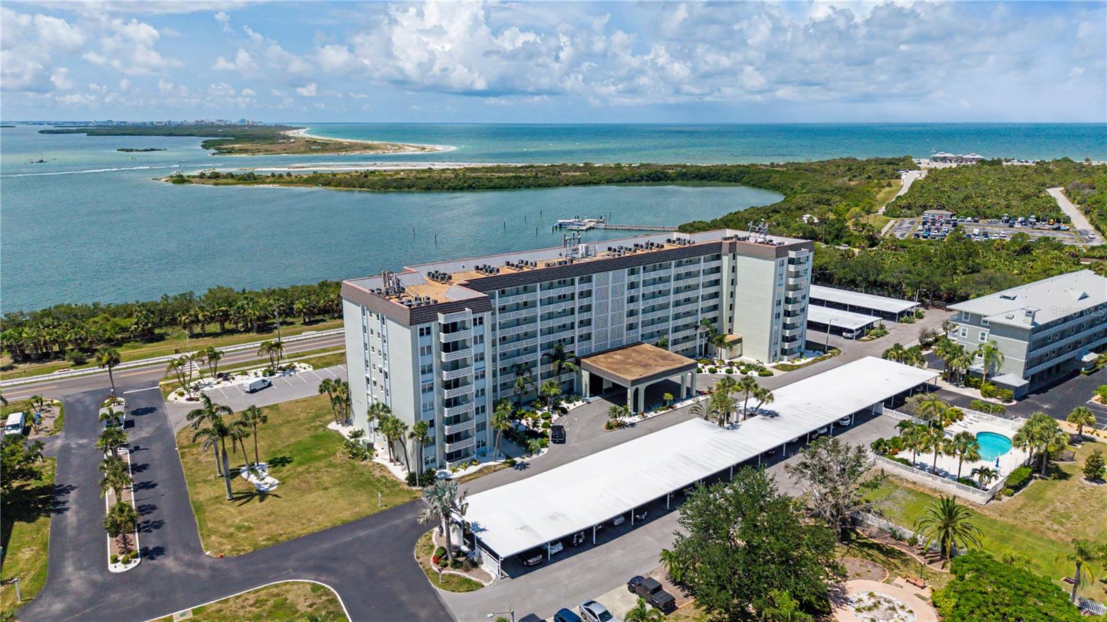Welcome to Royal Stewart Arms on Honeymoon Island, where every day feels like a vacation. This 2nd-floor unit offers 975 square feet of comfortable living with 2 bedrooms and 2 full baths. The primary bedroom features an en-suite bath with a walk-in shower, and the split-bedroom layout provides excellent privacy when guests come to visit.The kitchen is equipped with newer stainless steel appliances and offers generous cabinet storage. Step out onto your own private balcony and watch the colors of the sunset. From the balcony you will also catch some peek-a-boo views of St. Jospeh Sound.  The unit has been updated with a newer electrical panel and impact windows, giving you a solid foundation to personalize the space and make it your own.The community itself is one of the most scenically situated on Florida's Gulf coast. Residents enjoy a heated waterfront pool, clubhouse, sauna, fitness room, and pickleball courts. Just across the street, the Pinellas Trail leads directly to Honeymoon Island State Park. Charming downtown Dunedin is just a couple of miles to the south, offering waterfront dining and craft breweries.The unit carries a clean, neutral palette throughout — a blank canvas ready for your personal touches. Do yourself a favor and see this one before it's gone.