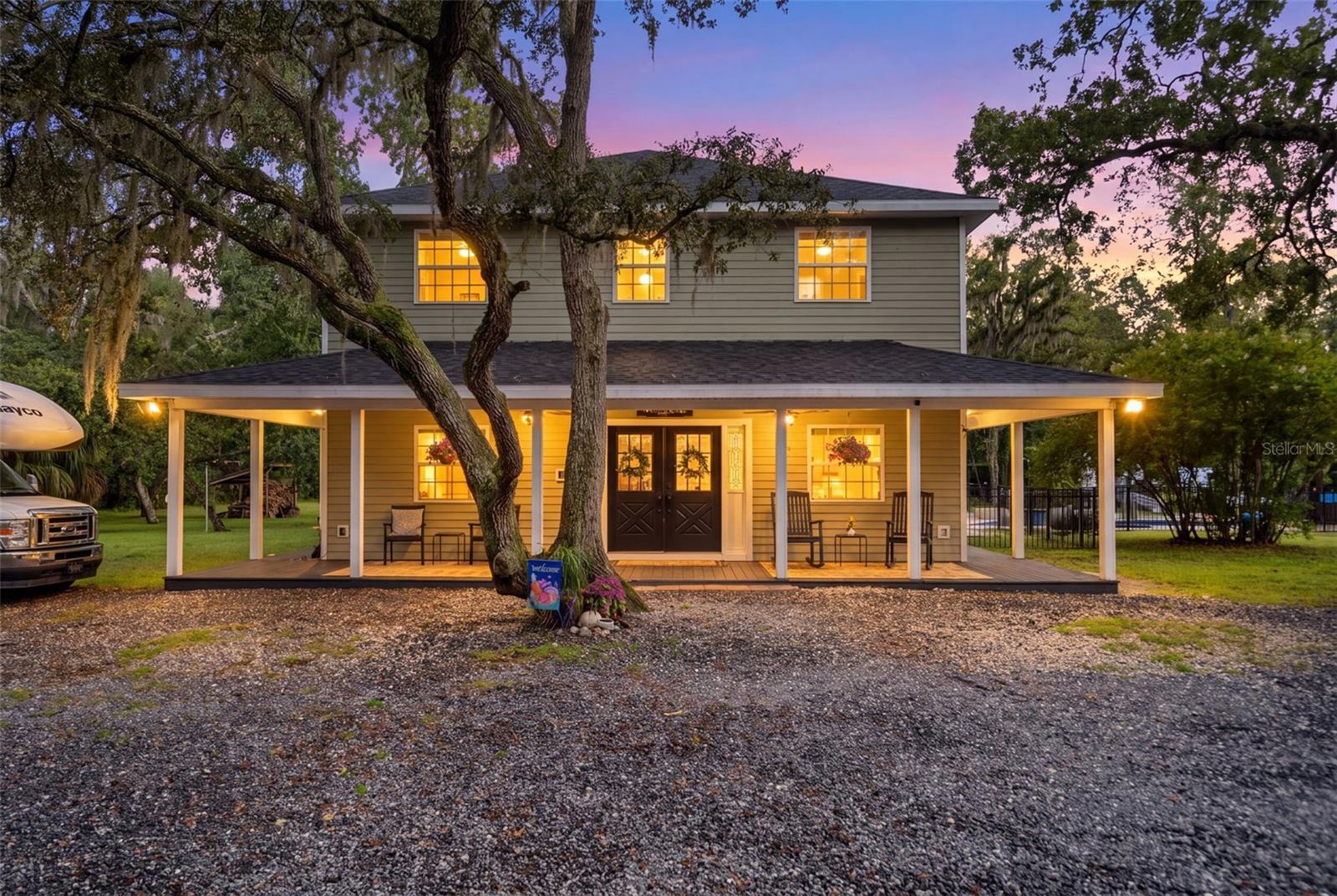 Sneak Peak!! More Pictures coming!! Welcome home! Tucked back on 2.5 private, oak-canopied acres in Spring Hill, this custom-built country home offers 3,100 square feet of thoughtfully finished living space — 4 large bedrooms, 2.5 bathrooms, and a dedicated home office — all at the end of a long, tree-lined driveway that feels miles from everything. A new roof, spray foam insulation, hurricane windows, and a propane tankless water heater keep this home efficient and worry-free, with electric bills that stay exceptionally inexpensive.Inside, warm hardwood floors and crown molding carry throughout a bright, open great room anchored by a stacked-stone wood burning fireplace and custom built-in cabinetry. The custom gourmet kitchen is a true showpiece, featuring a 6-burner propane commercial range, brand new GE Cafe, 4-door french door refrigerator and GE Cafe French-door double ovens alongside abundant cabinetry — a dream for anyone who loves to cook! It opens to a dining area where French doors lead out to a screened porch. A quiet, built-in-shelved office offers the flexible work-from-home space today's buyers are looking for, and two separate laundry rooms add everyday convenience rarely found in a home this size.Now for the fun part: step outside to your own resort-style, free-form pool complete with a sun shelf, attached spa, and water slide, all set on a spacious paver deck that is fully fenced with black aluminum fencing!! A wrap-around covered porch overlooks it all, and a covered cabana area with outdoor dining space makes entertaining effortless.Equestrian and hobby buyers, this one's for you: a fully fenced yard, horse stalls, a chicken coop, and room for RV or trailer parking round out this private, 2.5-acre setting.Custom-built, move-in ready, and set on one of the area's most private lots — this is Florida country living at its best, in the Pasco County area of Spring Hill, just minutes from everyday conveniences.And yes, the firewood stays too — because a proper country home comes with a head start on cozy nights by the fireplace!!