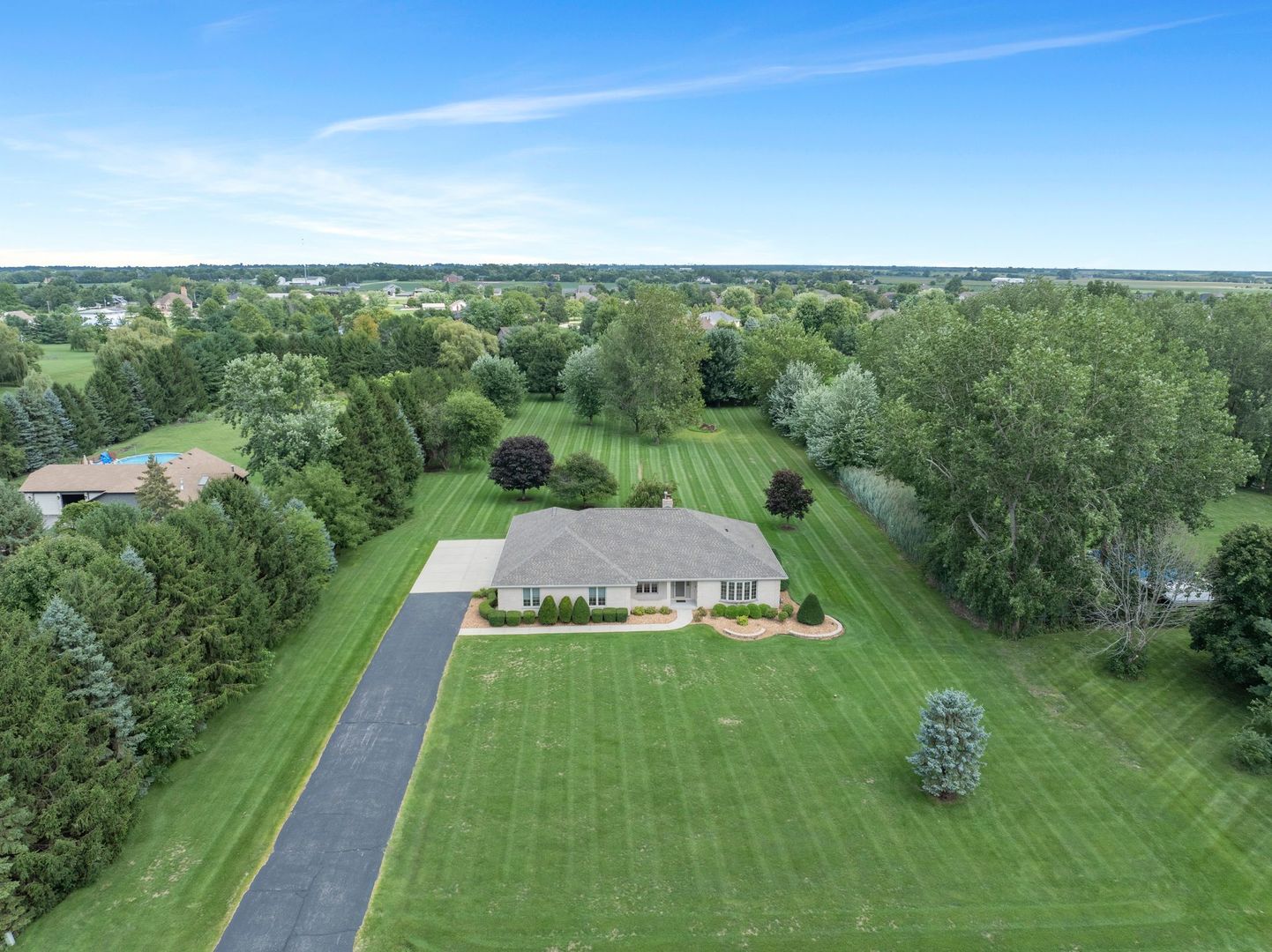 First time on the market! Pride of (original) home ownership shines throughout this extremely well-maintained, solid brick ranch on 2.5 acres in Manhattan. Offering over 2,900 square feet of living space, this home features 3 bedrooms, 2.5 bathrooms, and a huge unfinished basement with endless possibilities. Step inside the spacious foyer, where cathedral ceilings in the family room and a cozy brick fireplace immediately set the tone. The floor plan also includes a separate dining room and a versatile front room, perfect for a home office, playroom, etc. The kitchen provides ample cabinet space, breakfast bar seating, and room for a table, plus it comes fully equipped with stainless steel appliances. The primary suite offers his and hers walk-in closets and a private bath with a whirlpool tub and separate walk-in shower. Two generously sized secondary bedrooms also feature walk-in closets. The laundry/mudroom is conveniently located on the main level with its own private exterior access. Additional highlights include a 3-car attached garage, a massive unfinished basement with a large crawl space for storage, and a meticulously maintained, fully usable 2.5-acre lot. Surrounded by mature trees, open green space, and complete privacy, this property is ready to be transformed into the ultimate outdoor oasis. Roof, furnace and AC are two years young. Kitchen counter tops and appliances new in 2020. All of this is located on the edge of Manhattan, with quick access to New Lenox and Frankfort, and within award-winning school districts. This is one you won't want to miss!