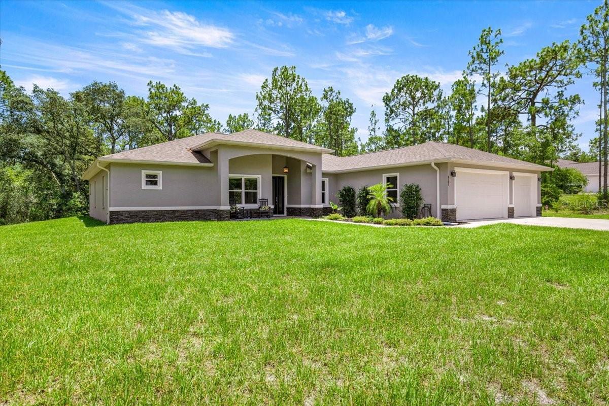 One or more photo(s) has been virtually staged. Seller is offering a $10,000.00 credit at closing to go towards closing cost or to buy down interest rate! Welcome to this 2022 beautifully custom designed 3 bedroom, 3 bathroom home offering 2558 sq. ft. of high-end living on a private 1-acre lot in the sought-after equestrian community of Pine Ridge. Each spacious bedroom features its own private en-suite bathroom, offering comfort and privacy for guests or multi-generational living. The primary suite is a true retreat, boasting 2 walk in closets with shelving, an oversized luxury bathroom with spa-inspired finishes, a soaking tub, walk-in shower, dual vanities, and ample closet space. The heart of the home is the chef's dream kitchen, complete with gorgeous quartz countertops, soft-close cabinetry, a walk-in pantry, high-end stainless appliances, and a large island perfect for entertaining. Enjoy elevated style with tray ceilings, vaulted ceilings, and recessed lighting that add warmth and elegance throughout the home. Need space to work, create, or simply unwind? This home includes a sun-drenched office/den with large windows that invite in an abundance of natural sunlight for an energizing start to your day. Ideal for remote work, reading, or your favorite hobby. Enjoy the peaceful Florida lifestyle from your front porch or relax on the oversized lanai surrounded by nature and serenity. The 3-car garage offers room for your vehicles, tools, or toys-plus additional storage space. The expansive lot offers plenty of space for gardening, recreation, or even a future pool. Located in Pine Ridge Estates, this home offers access to over 28 miles of trails, community amenities, and tranquil lifestyle just minutes from Crystal River, shopping, medical facilities, and the Gulf. You are also 78 miles from Orlando International Airport and 66 miles away from Tampa International Airport making it easy for you to travel to see those you love and for them to come see you! If you're looking for luxury, privacy, and lifestyle-all in one-THIS IS THE ONE! Call and schedule your showing TODAY!
