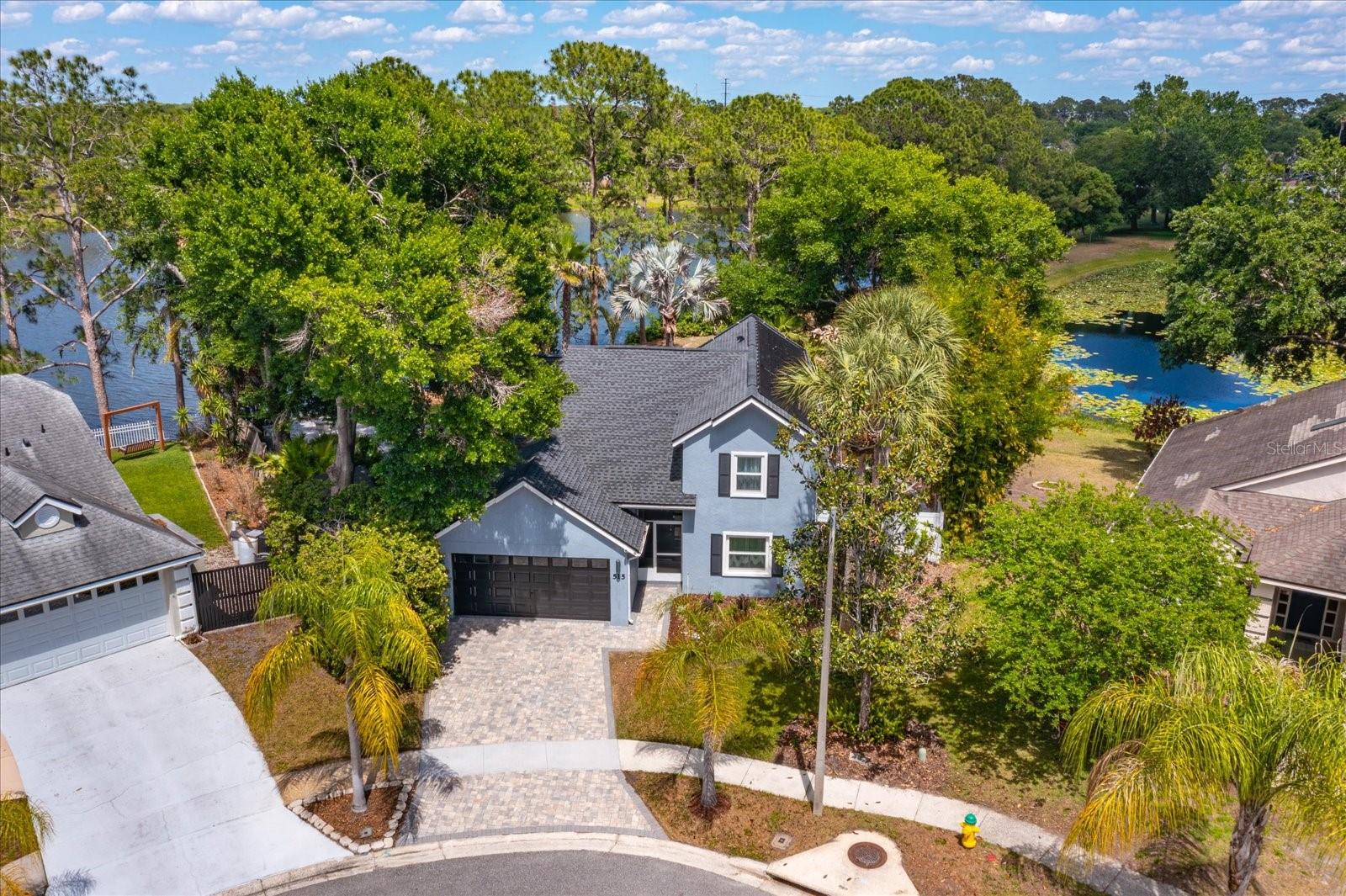 One or more photo(s) has been virtually staged. YOUR OWN BACKYARD OASIS!  Beautifully updated and renovated Lake Mary home with water views on a cul-de-sac!  Move-in ready home featuring a screen enclosed solar heated SALTWATER POOL with color changing pool light and a built-in cleaning system. Outdoor living is elevated with an expansive PAVER PATIO including fire pit, outdoor kitchen, prewire for hot tub, dog friendly PUTTING GREEN and lush landscaping with outdoor lighting.  SERENE WATER VIEWS create an unforgettable setting!  The completely RENOVATED KITCHEN offers 42 inch cabinetry with soft close drawers, QUARTZ COUNTERS, designer backsplash, stainless steel appliances including induction cooktop and built in oven.  The open floor plan showcases wood-look tile flooring, a built-in entertainment center with electric FIREPLACE and designer finishes.  Downstairs primary suite includes vaulted ceilings, custom walk-in closet, and a luxurious bath with dual vanities, soaking tub, walk-in shower plus direct pool access. Upstairs LOFT plus 2 freshly painted bedrooms with laminate wood flooring.   Flexible layout features private downstairs office with closet/4th bedroom.  Major updates include Roof (2022), A/C (2023), DOUBLE PANE WINDOWS AND SLIDERS with hurricane-impact (2018), and exterior paint (2020). Additional features include water softener, paver driveway, and outdoor shower. Great Lake Mary location near top-rated schools, Seminole Trail, shopping, and dining. READY TO MOVE IN NOW!