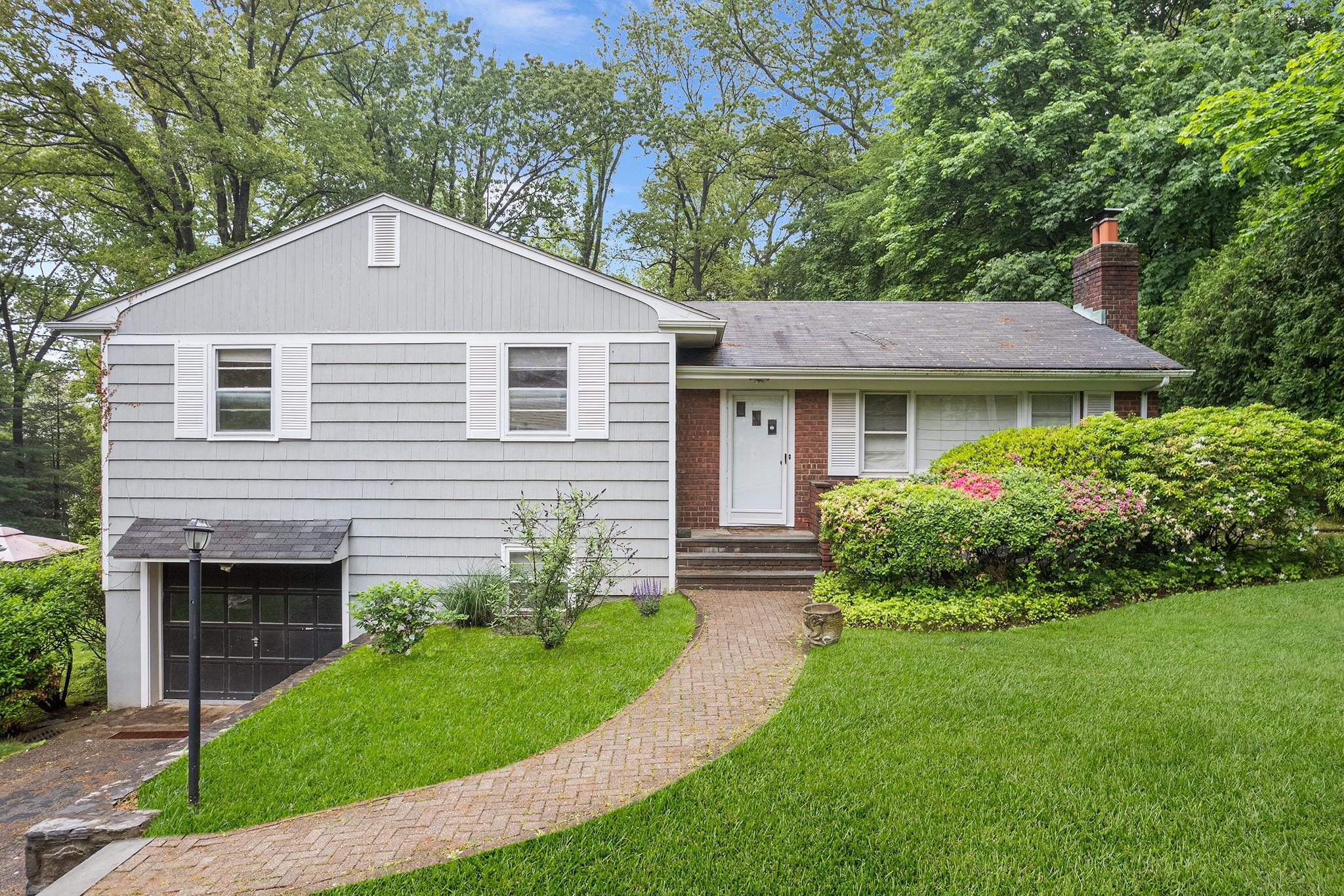 Nestled on a generous lot in a bucolic setting, this 3-bedroom, 2-bath single-family, ranch presents a rare opportunity to re-imagine something truly special in the highly acclaimed Ardsley school district. The main level offers a classic layout featuring a well appointed kitchen, adjacent formal dining room, a spacious living room with a fireplace being the focal point. Just off the dining room is a large walk-out deck ideal for indoor-outdoor living, with serene views and space for entertaining or relaxing. A few steps up from the main level is the bedroom wing including the primary with an en-suite bathroom, 2 additional bedrooms and a full bathroom. The lower level is partially finished offering a flexible living space, separate laundry area, abundant storage and access to the crawl space, enhancing both function and future design possibilities. The attached garage is spacious for one vehicle with direct access to the backyard along with a driveway that can fit multiple vehicles. Located in a peaceful, verdant corner of Westchester—yet just minutes from schools, shopping, dining, and parkway access. This home is brimming with potential, ideal for buyers looking to renovate, expand, customize to fit their lifestyle.