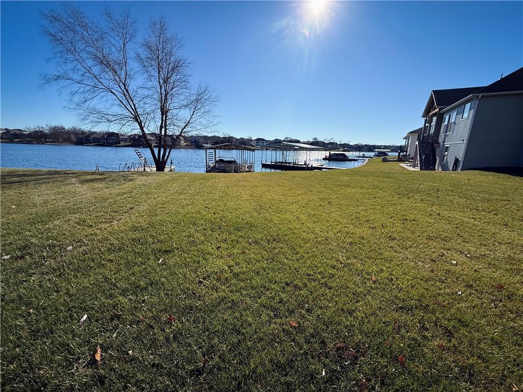 SELLERS MOTIVATED, please schedule a showing and bring us an offer! BACK ON MARKET because CONTINGENT BUYER didn't sell their home. LUXURY lakefront living at its finest in Creekmoor! You will want to schedule a tour immediately to see this stunning 1.5-story home located in Raymore. You will be amazed by breathtaking water views from almost every room. A dramatic two-story great room sets the tone with a see-thru fireplace, complimented by elegant tile throughout and a thoughtfully designed, high-end open floor plan kitchen perfect for entertaining. The primary bedroom is on the main floor with a large ensuite and walk-in closet. Upstairs the spacious loft offers versatile living space with additional bedrooms, including one bedroom with a private bath and the other two bedrooms accessible to a hollywood bathroom. All bedrooms have large walk-in closets. New carpet, fresh paint, refinished hardwood floors, new roof, newer HVAC and newer water heater make this home MOVE IN READY! The daylight basement features 9' ceilings, enhancing both comfort and functionality. The basement has two more bedrooms and a full bathroom, see-thru fireplace along with a movie projector and full kitchen. Exceptional upgrades are found throughout this refined residence.The expansive composite deck invites you to relax and take in the serene lake setting. Enjoy the premier lifestyle at Creekmoor, with resort-style amenities including a private lake, multiple pools, exercise trails, tennis courts, pickleball courts and an elegant clubhouse with a restaurant and bar. Schedule your tour today!