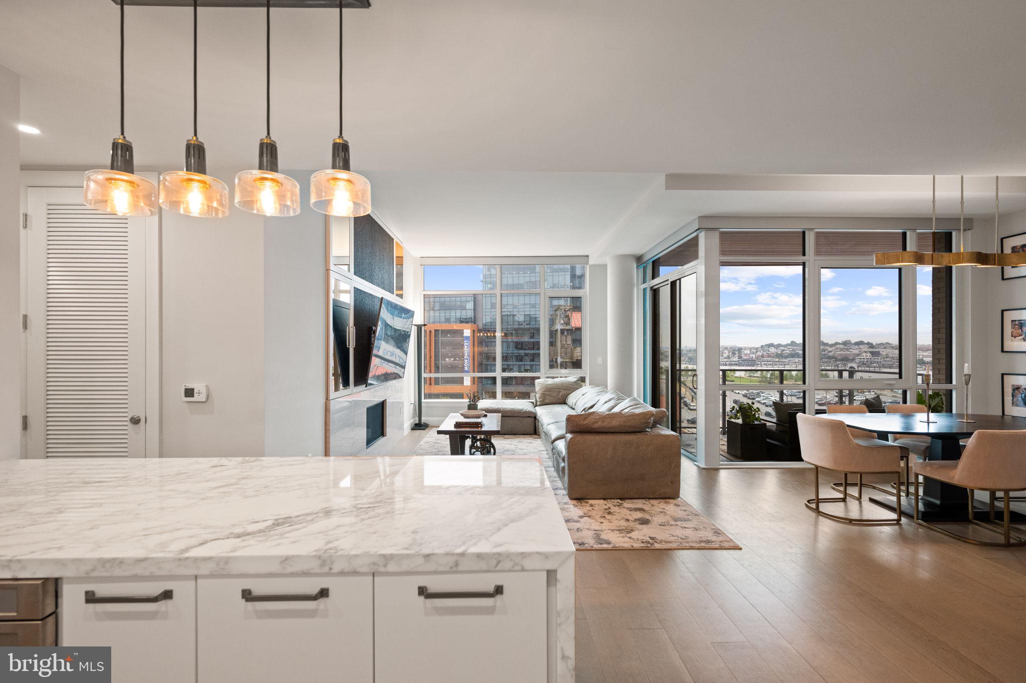 Experience luxury waterfront living at Liberty Harbor East! This stunning 2-bedroom, 2-bath residence offers over 1,500 square feet of sophisticated like-new space. With breathtaking panoramic views of the city and water, this is one of the few units in the Liberty to enjoy a private balcony off of the main living area. The unit is ideally situated in the building to maximize harbor views while providing a calm and quiet retreat in the heart of Harbor East. This smart home features soaring ceilings, oversized windows, wide plank oak floors, and a custom mirrored media wall with TV and gas fireplace. The spacious chef’s kitchen boasts Italkraft cabinetry, Thermador appliances, and a waterfall marble island- perfect for any home chef! The spacious primary suite offers floor-to-ceiling windows, a custom California Closet, and a spa-like en-suite bath with Carrara marble, Kallista & Kohler fixtures, and dual vanity. A split layout ensures privacy within the unit. The second bedroom is generously sized with a walk-in closet and an additional hall full bathroom. One garage space is included in the purchase. Residents enjoy unmatched amenities at the Liberty including a rooftop infinity pool, state of the art fitness center, pet park, concierge lounge, private dining, and direct access to Whole Foods. Steps from top dining, shopping, and waterfront paths—this is the ultimate downtown lifestyle.