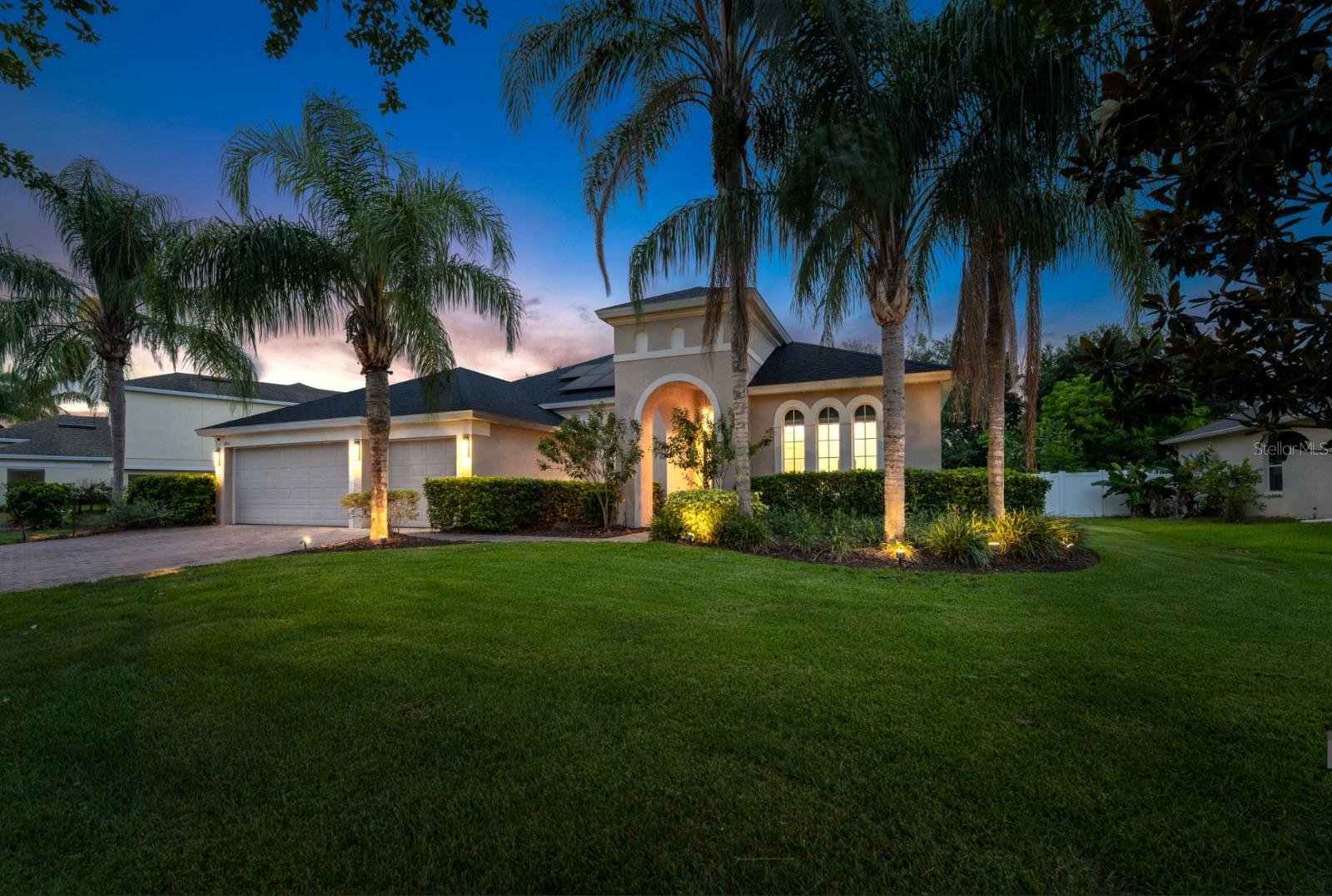 Nestled within the private, gated Legacy community, this one-of-a-kind contemporary residence is a masterclass in design, technology, and luxury. Set on a 12,009 sq. ft. lot, the home has been meticulously enhanced between 2021–2025 with $498,000 in premium upgrades, offering a level of refinement rarely found in new construction. The thoughtfully designed open floor plan features soaring 11' ceilings, floating ceiling details prewired for ambient lighting, and expansive 48”x24” imported European porcelain tile flooring throughout. Interior finishes include 8' solid-core 5-panel shaker doors, 8" baseboards, and level 5 smooth-finish drywall for a sleek, modern aesthetic. The Pininfarina-inspired kitchen is a true showpiece highlighted by floor-to-ceiling custom white oak cabinetry with Blum Tip-On system + motorized garage drawer, a living art feature above the coffee bar, and a 15' Cambria book-matched quartz island with deep composite sink, smart Delta faucet, and cabinetry on both sides. The appliance suite includes GE Monogram double wall ovens, microwave/oven, Bosch dual-compressor refrigerator, Monogram induction cooktop, Wolf ceiling-mounted hood, and Bosch panel-ready dishwasher. The expansive 698 sq. ft. primary suite includes a 16’x11’ Coblan Italy walk-in closet (ready for customization) and a spa-caliber bath with floor-to-ceiling Calacatta porcelain tile, curbless 5’x5’ frameless glass shower with Grohe fixtures, floating vanities with integrated LED lighting, Kohler sinks, quartz counters, chrome Delta faucets, dual LED mirrors with defoggers, soaking tub, Amba heated towel warmer, custom cabinetry, and a Toto Washlet+(Bidet).Two additional bathrooms feature matching high-end finishes. A large office with closet offers flexibility as a 5th bedroom or guest suite. Tech-forward features include a Ubiquiti business-class network system with ceiling-mounted wireless access points, Cat6 cabling (10Gbps ready), a dedicated 84” equipment rack, 13-camera video system, EcoBee 4 smart thermostat, and Nest Protect smoke detectors. Energy-efficient living is ensured by a 15.2kW solar system with Enphase micro-inverters (avg. electric bill $35/mo), R30 insulation, Bosch 5-ton 19 SEER heat pump, 104 LED recessed lights, Reme Halo air purification system, and Stiebel Eltron instant hot water heater. Home also includes a whole-house water softener & filtration system, new PEX plumbing, and Wi-Fi irrigation. Outdoor living is elevated with a smooth-finish stucco lanai that flows from the interior tile, overlooking a 15,000-gallon saltwater pool. The 3-car garage features epoxy flooring, finished walls, and a mini-split HVAC system—ideal for a gym, workshop, or car collection. The laundry room includes custom cabinetry, white quartz counters, deep composite sink with Delta faucet, LG washer/dryer suite, and LG Sidekick washer. Located near top private schools, Lake Jessamine, Cypress Grove Park, and just 10 minutes to downtown Orlando, The Mall at Millenia, Orlando Health, and ORMC. Also convenient to Orlando International Airport (15 min), Universal Orlando and Restaurant Row (17 min), and Lake Nona’s Golf & Country Club and Medical City (24 min). This residence offers unmatched luxury in one of Central Florida’s most desirable settings.