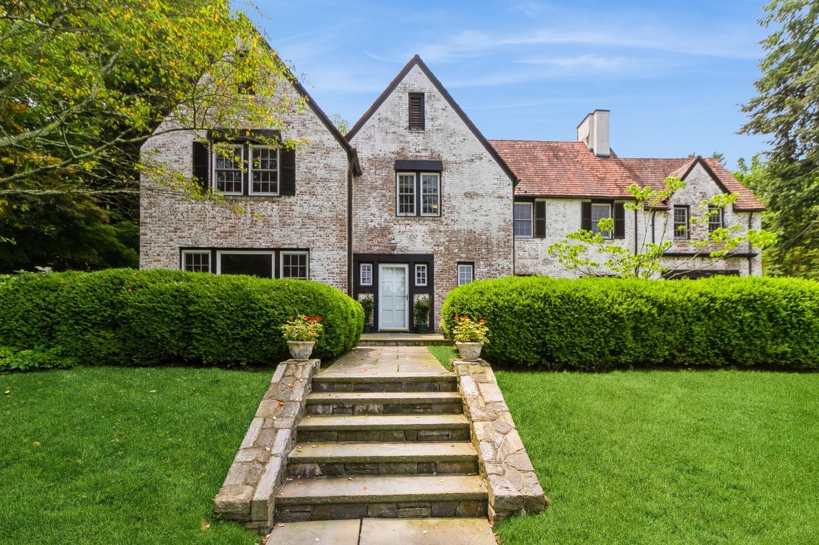 50 Overlook Drive, an elegant 6-bedroom colonial Tudor set in a quiet, tree-lined neighborhood. With fresh upgrades completed this month, including interior repainting, carpet-removal to expose wood floors. This one-of-a-kind home is a must see. 
Meticulously maintained heating and cooling systems, brick exterior, and a classic-tile roof are some of the exceptional features this home can offer. Homes built to this quality are a rare find. Constructed in 1929, the home is also graced with soaring ceilings, intricate period moldings, and expansive sunlit interiors.
Designed for both grand entertaining and comfortable living, this spacious home is roaring with charm and can suit a variety of tastes and living styles. The first floor offers a living room with fireplace, an all seasons sunroom, a bright and airy dining room, a kitchen with pantry and wet-bar, a half bath, and an in-law or au pair suite with a full bath. Upstairs features 5 bedrooms and 3 full baths, a grand hallway, and attic access. Additional recreational space is provided in the finished basement, with a family room, a gym, and large mudroom, a half-bath, and a utility room.
The beautifully landscaped 1.2-acre lot boasts stunning specimen plantings and a private stone patio adjacent to the all-seasons sunroom. There is also a charming bridge, designed by renowned architect Ned Baldwin, leading to a park-like setting in the backyard. 
This is an incredible opportunity to own a truly distinguished home in one of Chappaqua’s most desirable neighborhoods. Experience the perfect balance of classic architecture and modern luxury in this extraordinary residence, in a home that is built to stand the test of time.