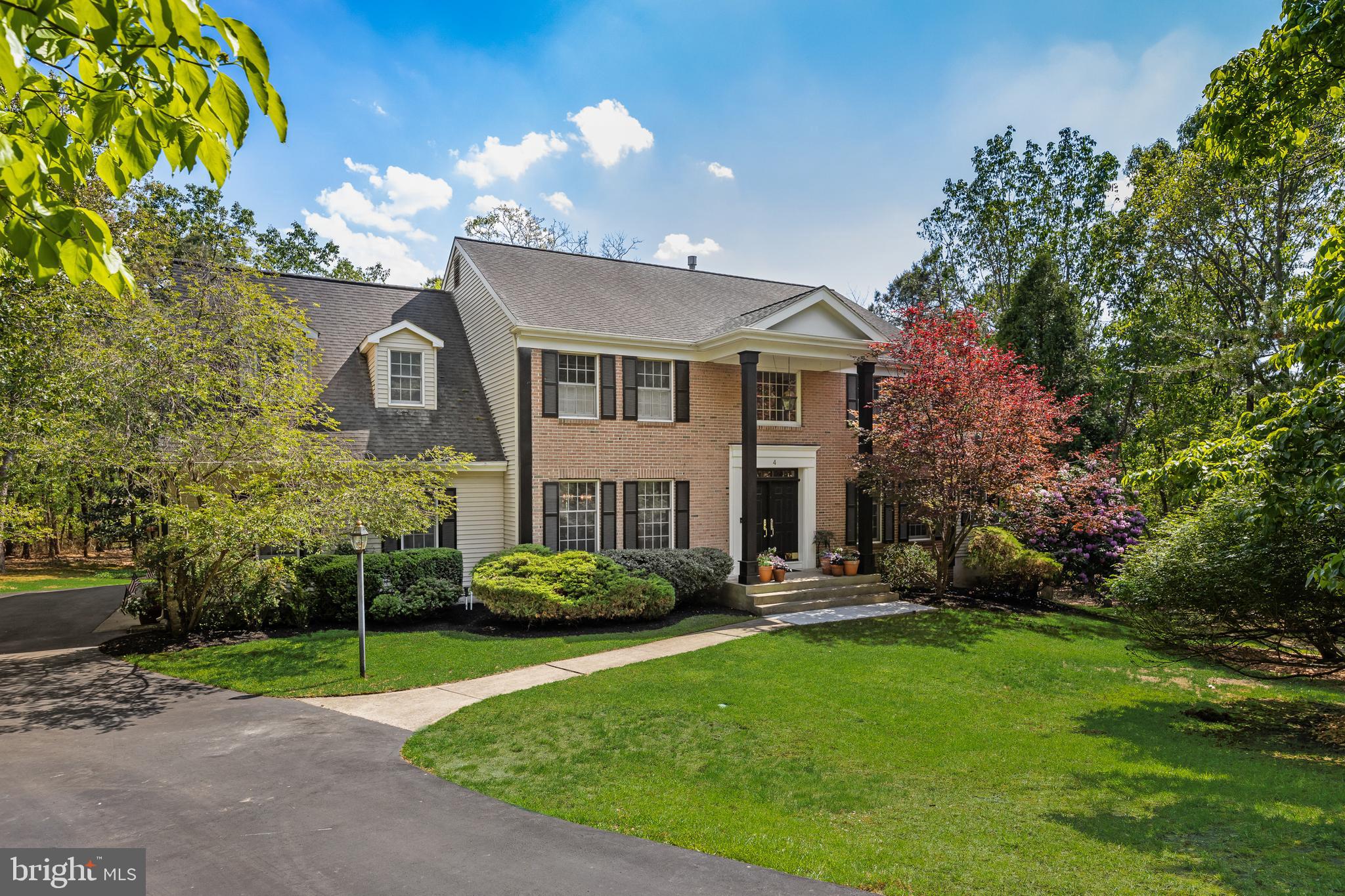 Experience refined living at 4 Irongate, an extensively updated custom residence privately situated on a beautifully wooded one-acre cul-de-sac lot in one of Medford’s most desirable neighborhoods. A dramatic two-story foyer with a sweeping spiral staircase, detailed wainscoting, and crown molding sets the tone for the exceptional craftsmanship found throughout. Elegant formal living and dining rooms, a private library with dual French-door entrances and custom built-ins, and a spacious family room with decorative ceiling beams, custom millwork, and gas fireplace create timeless appeal. The gourmet kitchen, completely remodeled in 2019, features quartz countertops, a 9’ butcher-block island, cast iron farmhouse sink, Wolf six-burner range with double ovens, 42” Sub-Zero refrigerator/freezer, built-in microwave, and Bosch dishwasher (2026). An adjoining dining area provides seamless access to the deck and serene backyard setting. Rich Hickory hardwood flooring, oversized baseboards, crown molding, and extensive custom trim enhance both the first and second levels. Upstairs, the expansive primary suite offers a private sitting room, impressive 20-foot walk-in closet with dual entrances, and a luxurious spa-inspired bath renovated in 2019 with clawfoot tub, oversized custom shower, dual vanities, and convenient second-floor laundry. Four additional bedrooms provide generous space and storage, while the secondary full bath was beautifully remodeled in 2025. The fully finished walk out basement offers exceptional versatility with a large recreation area, wet bar, office/media spaces, powder room, hickory hardwood floors and abundant storage, and room for billiards, table tennis, or entertaining. Additional improvements include dual-zone HVAC systems (2021 & 2026), hot water heater (2021), roof replacement (2009), and a three-car garage with built-in shelving. Conveniently located near downtown Medford, shopping, dining, and everyday amenities, this exceptional property combines luxury, privacy, and comfort in a premier location.