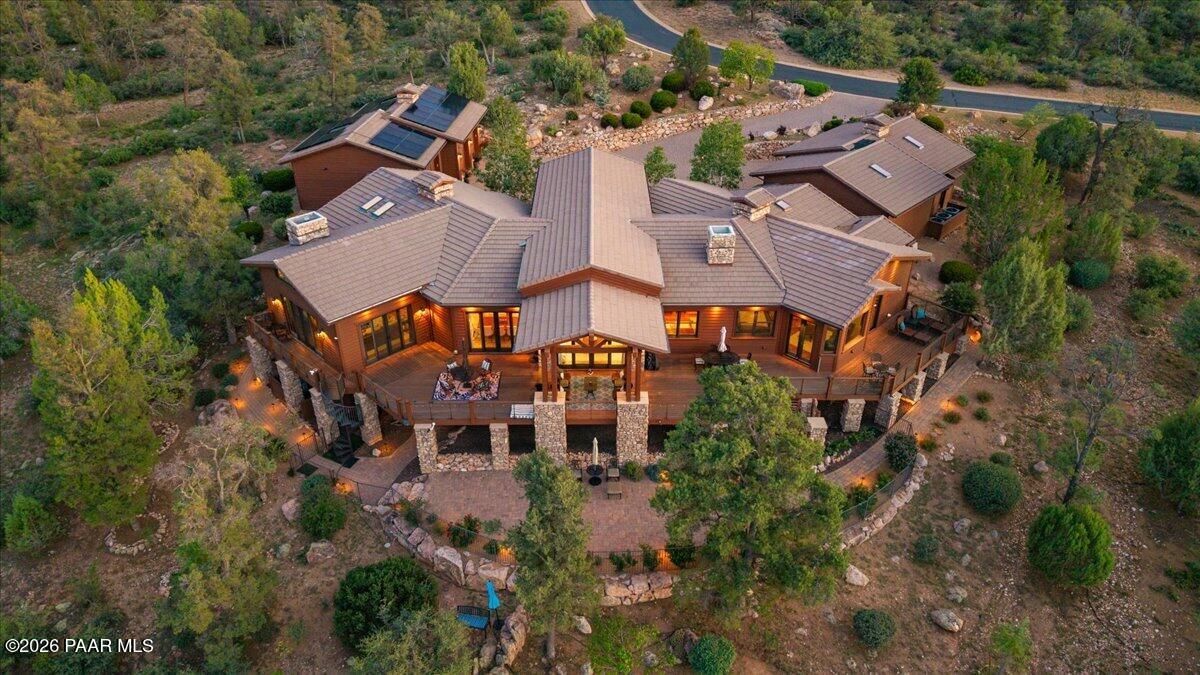 Beautiful ''Modern Mountain Ranch Luxury Estate'' offering 6 Bedrooms | 4.5 Baths | 5,094 SF Main Residence | 616 SF Guest House | 5,710 Total SF | 2.01 Acres | 5.5-Car Garage. The open-concept great room & chef's kitchen showcase soaring vaulted ceilings, rich cherry hardwood flooring, furniture-grade cherry cabinetry, custom millwork, walls of glass, dramatic floor-to-ceiling stacked-stone fireplaces. The kitchen features natural-stone slab granite countertops with full-height backsplash, an oversized island with professional-grade Wolf range. A custom den with stone fireplace & extensive built-ins, spacious master suite with sitting area, outdoor access & spa-inspired bath featuring dual vanities, jetted soaking tub & oversized walk-in shower. Designed for entertainment, the estate includes a wine room, theater/media room, workout room & expansive outdoor patios overlooking the distant golf course and mountains to the North, while a custom-designed creek flowing in front of the home creates a tranquil arrival. A private guest house with kitchenette & Walk -in Shower with a 1.5 car garage provides exceptional accommodation. Nearly every major system has been enhanced, including a new roof, four HVAC systems, owned solar panels with battery backup, water heaters, whole-house water filtration/softener, Phyn smart water monitoring, smart thermostats, Control4 automation, EV charging, LED lighting, interior/exterior paint, gutters, enhanced security and crawlspace improvements. Additional upgrades include remodeled baths, new fireplaces, designer lighting, pantry improvements, new landscaping, smart irrigation, updated fencing. Close proximity to the club amenities which include an 18-hole Jay Morrish-designed golf course, clubhouse, Coop's Coffee House, pickleball and tennis courts, outdoor pool, fitness center, concierge services and approximately 14 miles of hiking and biking trails, delivering an exceptional blend of luxury, recreation and mountain living.