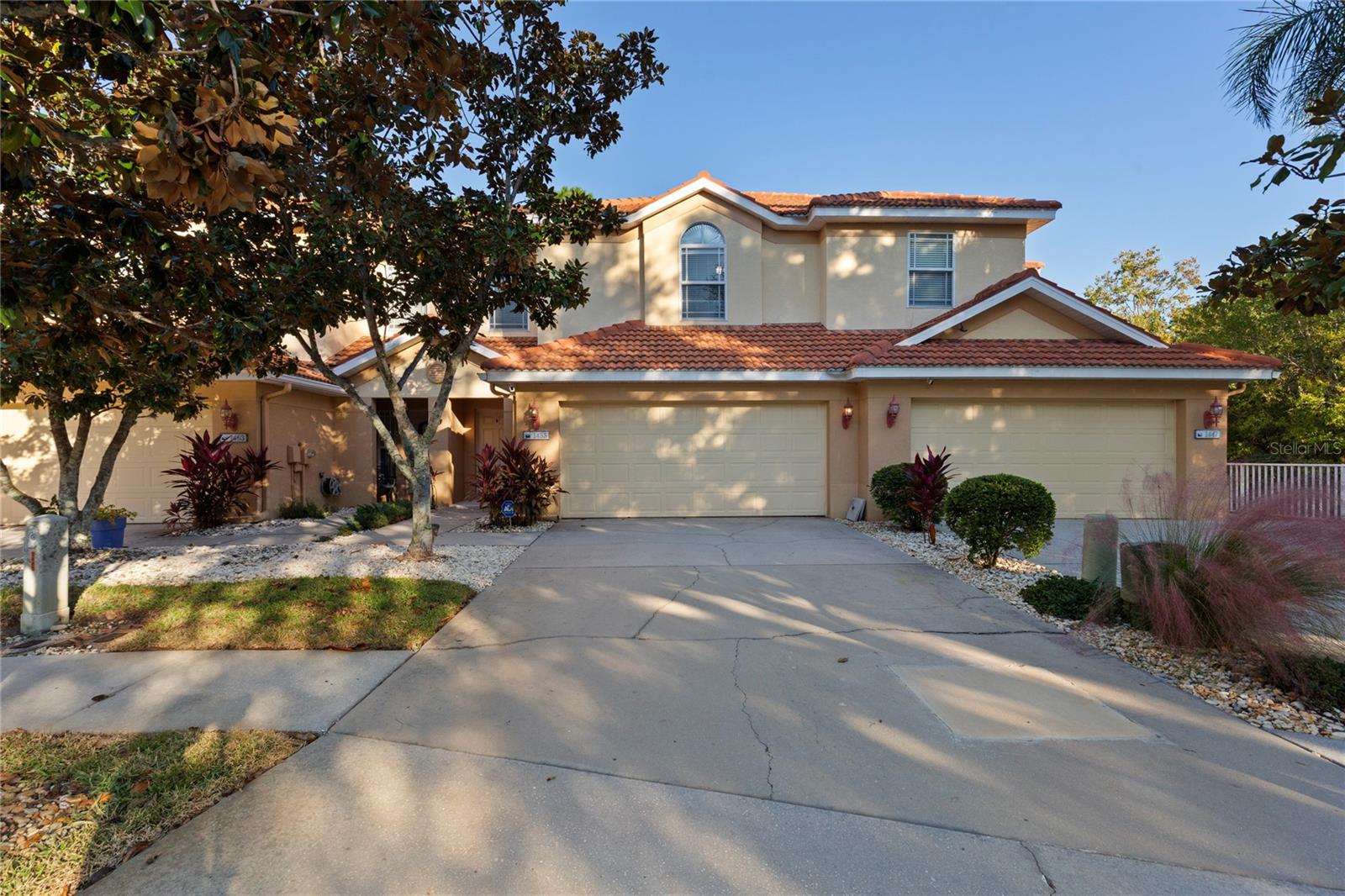 Tucked away on a quiet cul-de-sac near the scenic Pinellas Trail, this Mediterranean-style home blends timeless charm with modern comfort. Its terracotta tile roof, installed about a decade ago, offers lasting protection, while impact-rated windows add peace of mind. Featuring three bedrooms, two and a half baths, and a spacious two-car garage, it's been recently painted inside and out for a fresh, inviting feel. High ceilings and an open-concept design are kept cool by a 2022 air conditioner. The kitchen offers space to dine in while showcasing 42-inch upper wood cabinets, lower wood cabinets topped with granite counters, and 2023 stainless-steel LG appliances. A breakfast bar opens to the dining/living area, where wood floors shine, a half bath hides beneath the stairs and tall sliding glass doors open to a screened porch with serene pond views. Upstairs, luxury vinyl floors and high ceilings are throughout. A room separates a full bath and two guest bedrooms from the primary suite, which features a tray ceiling, walk-in closet, and en-suite bath with dual sinks, oval-shaped soaking tub and glass-enclosed shower. Low-maintenance living comes with a low $320 monthly HOA fee covering the roof, exterior, landscaping, cable TV, high-speed internet and ADT security. Just minutes from Sunset Beach, Innisbrook Golf Resort, and the lively dining and shopping of Tarpon Springs, Palm Harbor and Dunedin, this home delivers the ideal mix of safety, comfort and convenience.