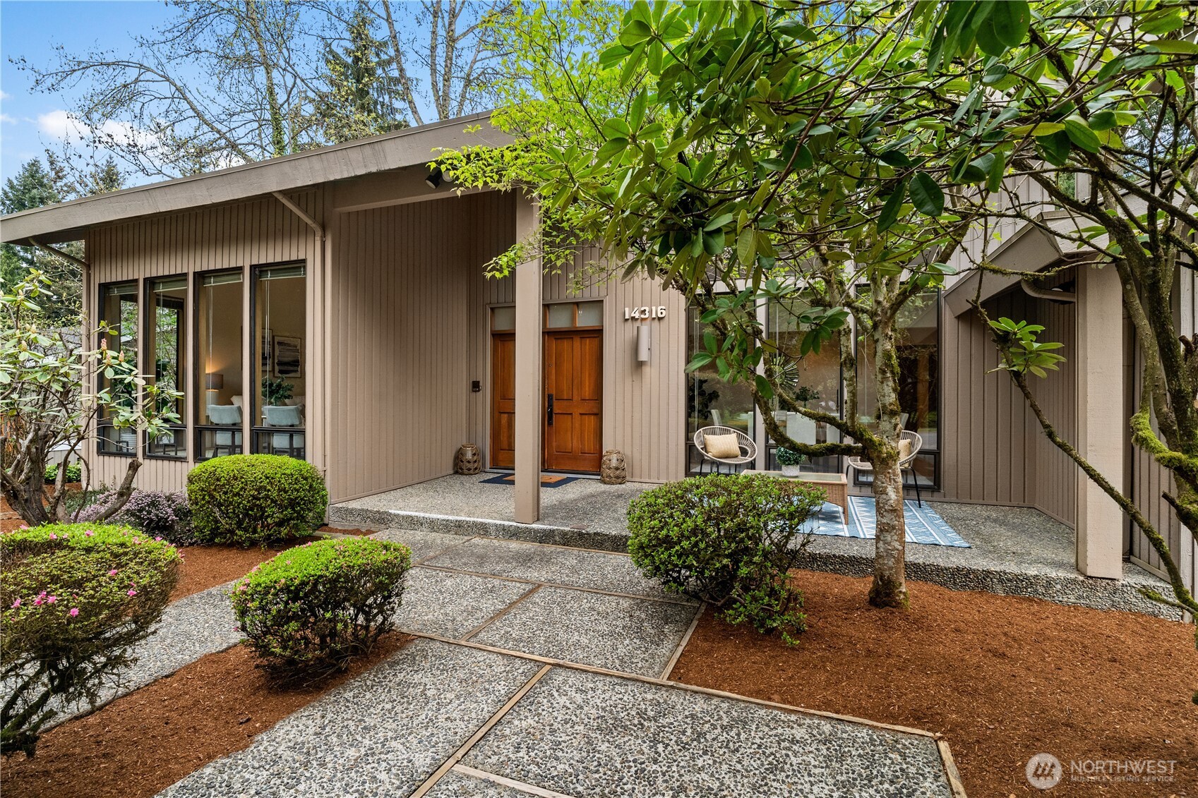 Set in a sought-after East Bellevue neighborhood, this distinctive home offers a rare, flexible floorplan designed for everyday living as well as entertaining. It features formal living & dining rooms, family room, a den, & a jaw dropping bonus room.    A dramatic two-story entry opens to light-filled interiors, where soaring windows & vaulted ceilings create an airy, inviting feel in the living & dining room areas. Hardwood floors span the main level, adding warmth and continuity. A main floor den works equally well as a home office or reimagined as a speakeasy lounge.    The kitchen combines function and style with hardwood cabinetry, stainless appliances, and peninsula seating—ideal for casual dining. Just beyond, the cozy family room with gas fireplace connects seamlessly to a large deck and backyard, creating effortless indoor-outdoor entertainment flow. A spacious bonus room with mid-century inspired lighting offers endless possibilities—media room, fitness space, studio, or gathering hub.    Outdoors, enjoy a rare 1/3-acre setting with mature trees, curated landscaping, and a winding gravel path—perfect for entertaining or quiet retreat. A full-height basement with separate exterior access provides exceptional storage or hobby space.     This is more than just a home—it’s a space to gather, relax, and enjoy—whether hosting unforgettable evenings or savoring the calm of your own private retreat.  Don’t miss seeing this one of a kind home.  Call for an appointment today!