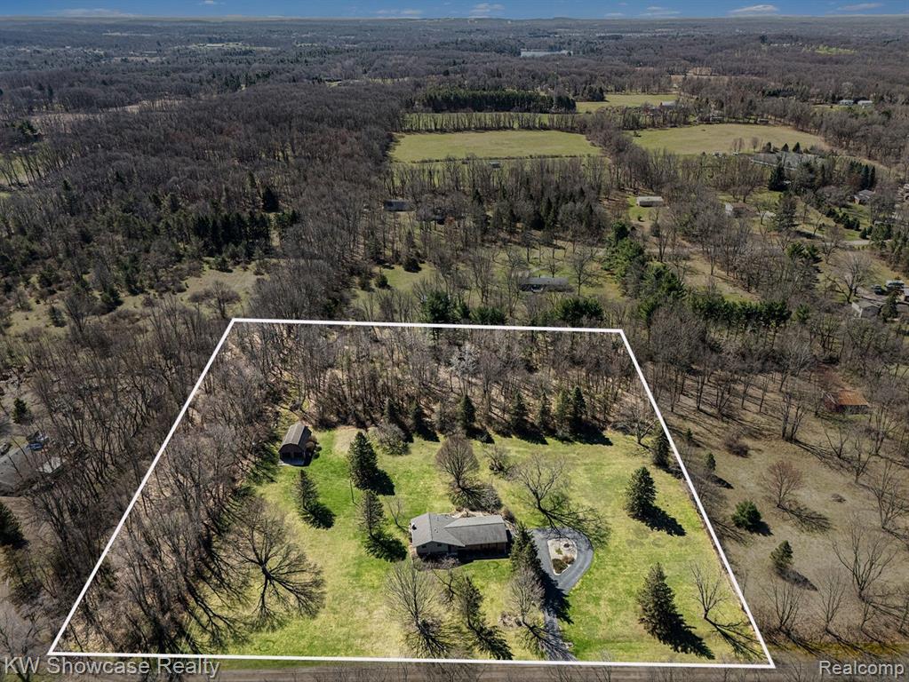 (OPEN SUNDAY 1-3 PM)  Tucked away on a private road in the heart of Highland Township, this attractive 4-bedroom, 2.5-bath home offers the perfect blend of peaceful country living and modern convenience. Set on over 5 + acres of meticulously maintained land, the property provides a rare combination of spacious comfort, privacy, and natural beauty.Large windows throughout flood the home with natural light, creating bright and airy living spaces. The open floor plan flows seamlessly, making it ideal for both everyday living and entertaining. The finished basement is perfect for additional living space or hosting guests, with plenty of storage throughout.The generous family room features a Brick Wood Burning Fireplace &  a door wall that opens to a spacious Patio & Deck  — ideal for summer relaxation and evening gatherings under the stars. A 2.5+-car garage provides ample room for vehicles and recreational equipment, while the 24x32 pole barn with concrete floor offers excellent additional storage or workshop space.Additional highlights include: • Wall side windows • Beautiful asphalt circular driveway • Award-winning Huron Valley Schools * R-60 Blown in Attic Insulation.Surrounded by lush, well-maintained landscaping and abundant wildlife, this home is truly a private sanctuary that feels worlds away, yet remains conveniently close to area amenities. This is more than a house — it’s a lifestyle where privacy, comfort, and natural beauty come together.