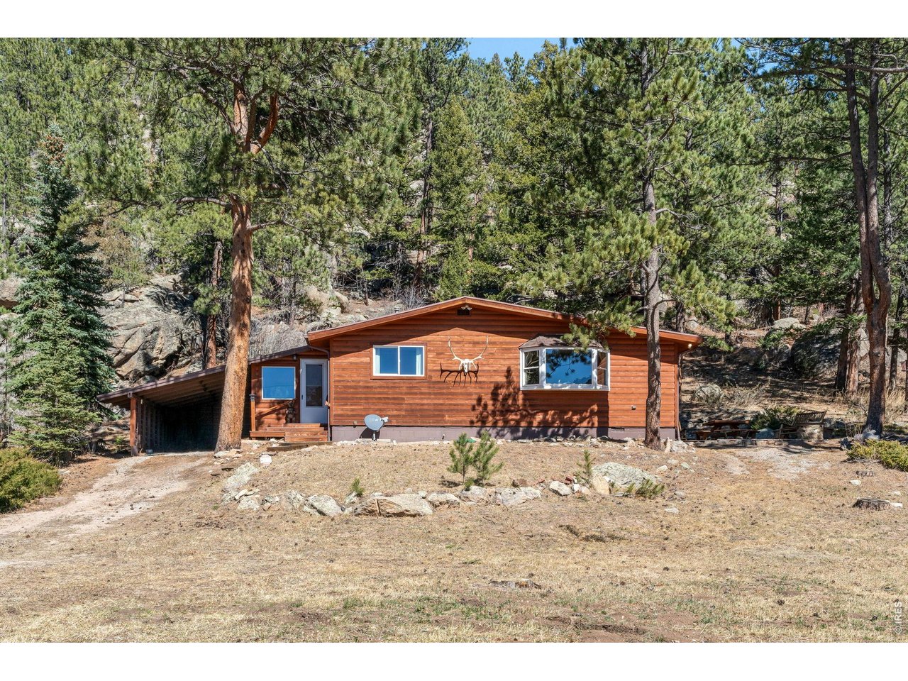 Mountain charm and privacy in the foothills. Nestled in the peaceful foothills above Lyons, this inviting mountain retreat offers the perfect blend of rustic charm, privacy, and Colorado outdoor living. Set on approximately half an acre of wooded land, the property provides a serene escape surrounded by natural beauty, while still within convenient reach of town, with plenty of parking for your guests. The home features 3 bedrooms and 2 bathrooms with a functional layout designed for comfortable everyday living or weekend getaways. Large windows invite natural light and frame the surrounding forested landscape, creating a warm and welcoming atmosphere throughout the home. Whether you're sipping coffee on the patio, watching local wildlife, or exploring nearby trails, the property's expansive lot offers room to relax, entertain, or simply enjoy the quiet mountain setting. You and your guests will enjoy Big Elk Meadows amenities, which include fishing, boating, a heated swimming pool, tennis courts, a picnic pavilion, a playground, horseshoe pits, and a pasture for your horses. There are also numerous hiking trails, as this community is surrounded by Roosevelt National Forest. It is in close proximity to Estes Park, Rocky Mountain National Park, Lyons, Longmont, and Boulder. Whether you're looking for a full-time mountain residence, weekend retreat, or investment opportunity, 434 Aspen Dr offers a rare chance to own a slice of Colorado mountain living.
