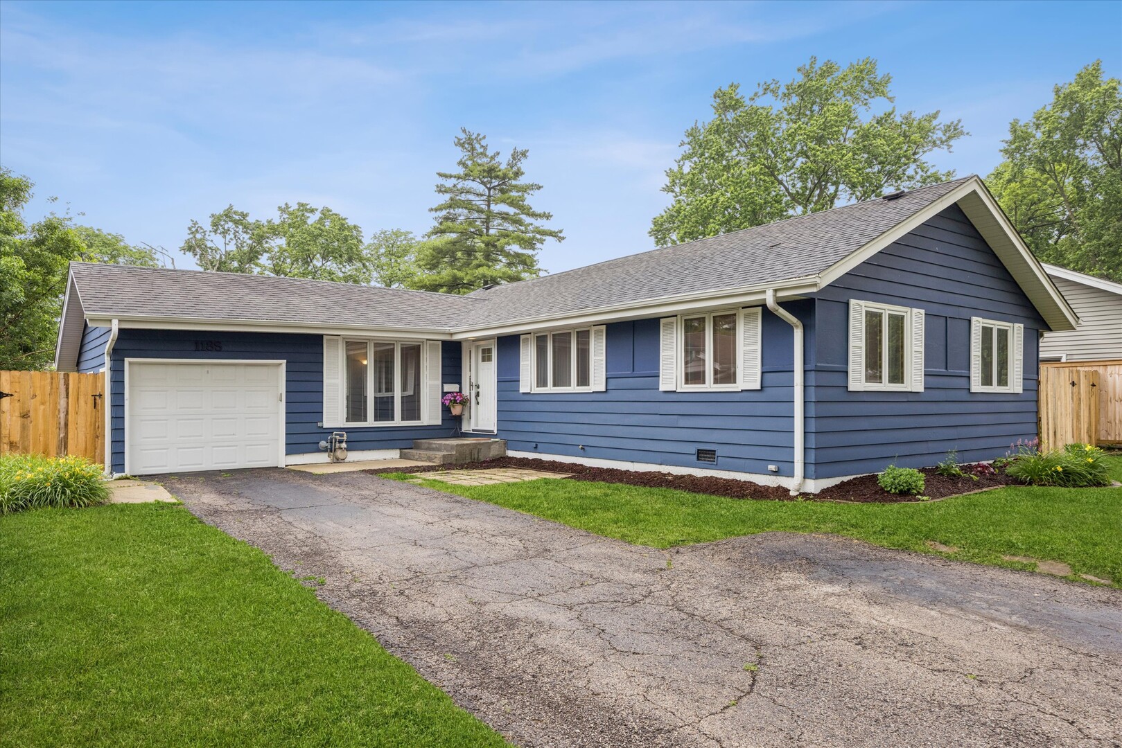 Seeking easy living in a lovingly maintained ranch home in the heart of Wheaton? This is the one! This three-bedroom home features two full bathrooms, hardwood floors, generous storage, and an updated kitchen and bathrooms. The spacious finished basement provides laundry and storage, plus an exceptional additional living area with plenty of room to relax, entertain, or work from home. Enjoy a location just steps from Graf Park, DuPage County Fairgrounds, Emerson Elementary, and Monroe Middle School, with easy access to downtown Wheaton, shopping, dining, and the Metra train. Step outside to enjoy the fully fenced backyard, with a partial new fence and gates (2026), side deck, and storage shed-perfect for summer evenings, pets, play, or gardening. An attached garage and extra-wide driveway provide plenty of parking. Recent improvements include a freshly painted exterior and new AC (2025), new microwave (2024), new fans, lighting, and garbage disposal (2023), and a kitchen island, additional cabinetry, dishwasher, and garage door opener (2019). Extensively updated over the years, including windows, roof, furnace, refrigerator, washer, and dryer. See it today and move in just in time for Wheaton's 4th of July fireworks at Graf Park!