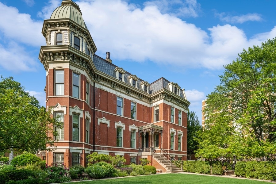 A sophisticated presence, landmark status, architectural integrity, and an unprecedented outdoor footprint for Wicker Park, 1407 N. Hoyne Ave. is a one-of-a-kind opportunity for the homeowner who wants an expansive city estate with pedigree and a modern program. Originally built for beer baron John H. Rapp in 1886, this 8250 SqFt-square-foot, 5 bed/4.3 bath single-family home underwent a multi-year renovation and restoration by Rugo Raff Architects.  Preserving elements of its Victorian charm while optimizing sightlines and integrating first-class finishes was paramount. This special home's unheard of 98' x 110' lot affords multiple green spaces, including a deep front yard with mature landscaping, a side yard with raised garden beds and a European-style pergola. Inside, an elegant entry plus an oval-shaped entry hall link to a lovely living room with an abundance of natural light, a traditional turret, and a wood-burning fireplace, and a formal dining room just beyond with hand-scraped walnut floors. The custom chef's kitchen stuns with O'Brien Harris cabinetry, white quartzite countertops, professional-grade Wolf/Sub-Zero appliances, an herb garden, a full butler's pantry, a breakfast dining space with banquette seating, and a built-in desk. The main level also features an intimate family room with built-in walnut cabinetry and a chic beverage center, and two beautiful limestone terraces accessed via French doors: a 12' x 23' west terrace for open-air entertaining and a 12' x 17' side terrace that's perfectly appointed for large-scale alfresco dining with an outdoor kitchen and a built-in grill.    A striking example of this home's flawless interior architecture is the centrally located, curving suspended staircase. The second level is devoted to two secondary bedrooms (one with custom bunk beds), the first of two laundry rooms, and an impressively spacious primary suite with a sitting area, a custom dressing room, a walk-in closet, and a marble-clad ensuite bath with two vanities, a soaking tub, and a deluxe shower. The third floor presents two designer offices--a handsome den with knotty alder wood floors and a gas fireplace, a cozy den with a wet bar, an exercise room, and yet another polished guest bedroom. But there's more... This truly magnificent home also comes complete with a fully finished garden level with a massive playroom that opens onto a basement terrace, a wine room, a kitchenette, another large guest bedroom with den perfect for related living, a second laundry room, a walk-in storage room, and a custom mudroom that connects to an attached garage. Additional callout details and amenities include restored original doors and hardware, custom woodwork and trim throughout, designer lighting and wallcoverings throughout, four total fireplaces, 97 Marvin windows, a Lutron lighting system, self-irrigating planters on both terraces, and an excess of custom interior storage. Walking distance to Wicker Park proper and the world-class shopping and dining that extends from the neighborhood's famed Six Corners, 1407 N. Hoyne Ave. is a one-of-a-kind home with uncompromising design and comforts. Coach house available separately and additional garage parking can be added if acquired, please inquire.