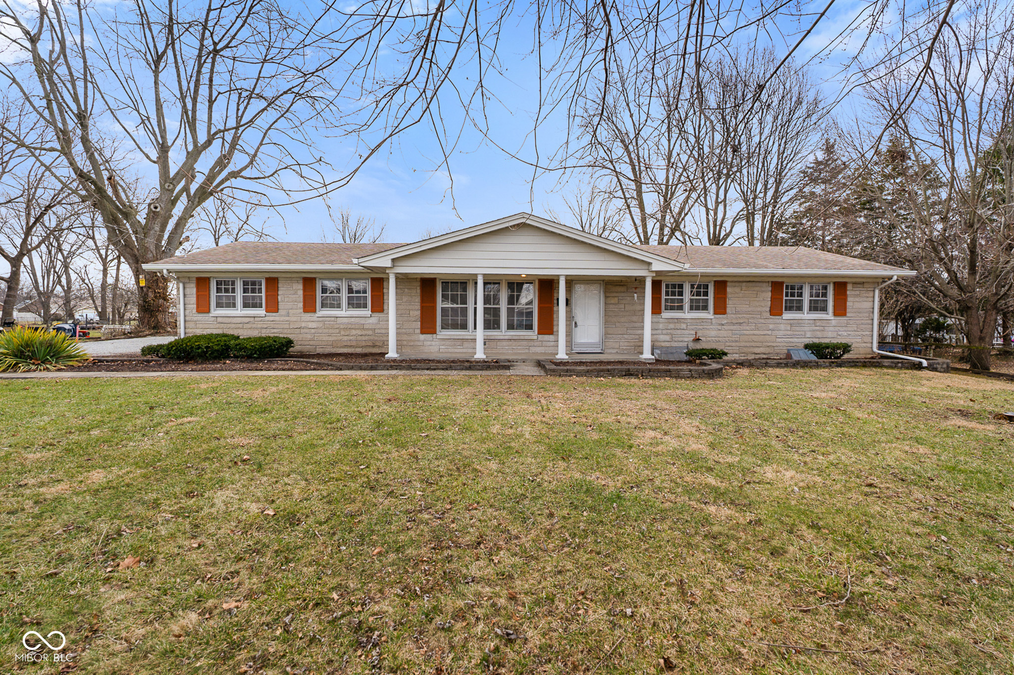 Welcome to 2215 Albany St, a charming single-family Bedford stone ranch in Beech Grove. This inviting home offers a perfect blend of comfort and space with three bedrooms and two bathrooms spread across 1,480 square feet. This residence sits on nearly an acre, providing a serene escape with a lovely backyard perfect for relaxation and play. Step onto the covered front porch, an ideal spot for morning coffee, or enjoy the sun porch overlooking the expansive backyard-a delightful setting for gatherings or quiet evenings. The convenience of a two-car attached garage and a basement adds to the functional appeal of this home. All 3 bedrooms have newly installed vinyl plank flooring. Under the carpet in the living room you will find  hardwood floors. This home has so much potential, just waiting for someone new to move in and bring their own touch.