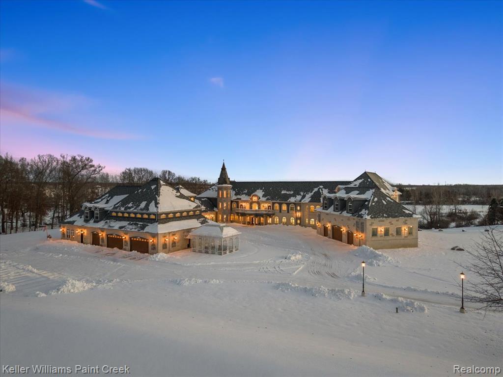 The Woods Chateau is an extraordinary custom French Provincial estate unlike anything on the market. Timeless craftsmanship, thoughtful design and breathtaking natural beauty come together in this private 14 acre lakefront sanctuary. This remarkable property was born from a true labor of love, uniquely hand designed by the owners & meticulously brought to life over many years. The result is an architectural masterpiece reflecting passion, precision & personal vision. Set against a backdrop of serene woodlands and shimmering water views, the estate offers a one of a kind living experience w/spacious, thoughtfully planned interiors that flow seamlessly to the outdoors. Designed for limitless living, the estate features a sophisticated integrated ADA compliant ramp system to three levels and generous proportions that ensure the grandeur is accessible to all without compromise. The floorplan spans over 33,000 finished sq ft, unfolding from a grand foyer w/decorative fountain and a dramatic two sided staircase. Beyond the main living quarters, a comprehensive business wing offers complete professional autonomy w/private office, conference room plus three independent main level studios, each featuring its own kitchen & living area. Discover themed quarters including the romantically inspired Romeo & Juliet suites w/connecting balcony and the opulent Honeymoon Suite featuring a private parlor. Indulge in the Natatorium, a breathtaking indoor pool room w/designer ceiling and retractable pool cover. The massive walkout lower level serves as a premier entertainment hub, housing a professional banquet center, tiered movie theater, a full gym w/sauna, professional kitchen and a fourth private guest studio. For the automotive connoisseur, heated garages provide a 13-car capacity, including a massive 8 car tandem bay. This is more than a home, it’s a legacy property for the discerning buyer seeking privacy, artistry & unparalleled craftsmanship in a secluded lakeside setting.