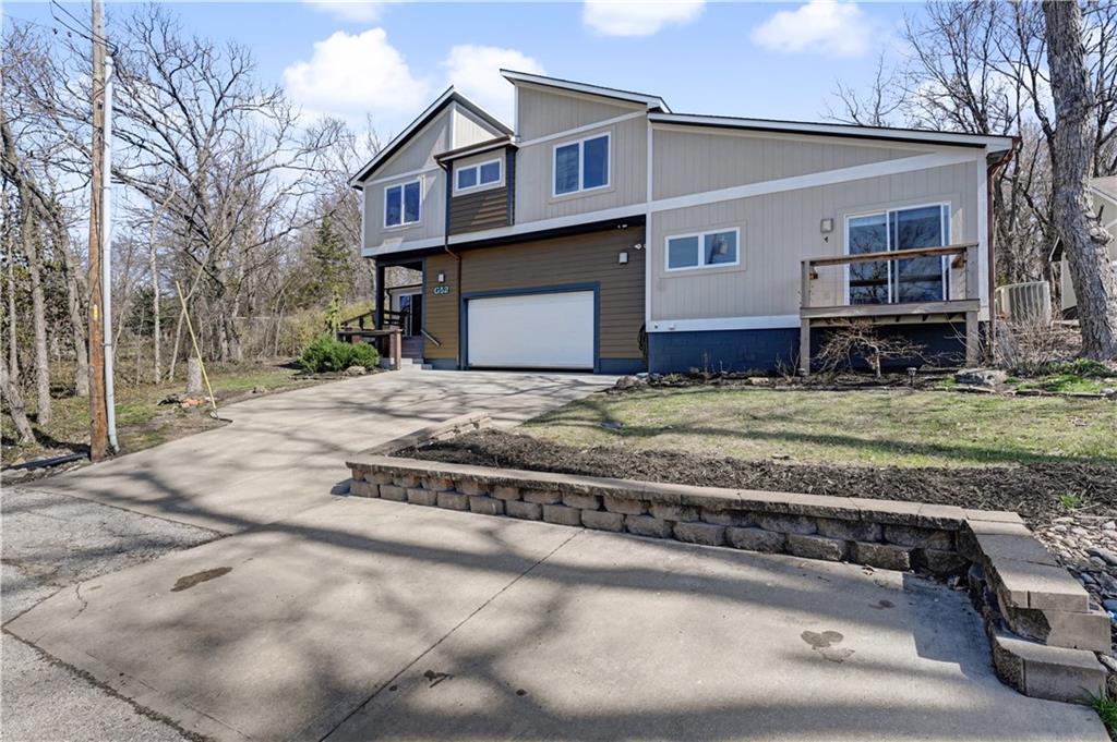 Some homes are houses. Others are a gateway to the lake lifestyle. Welcome to 52 G Street in Shawnee Cove, offering more than 3,750 square feet of living space designed for comfort, connection, and making memories at the lake. This spacious home features 5 bedrooms and 4.5 bathrooms, providing plenty of room for family, friends, and weekend guests who never seem to want to leave.Inside, you'll find generous living areas filled with natural light, updated finishes and a layout that works beautifully for both everyday living and entertaining. Whether it's hosting a summer dinner after a day on the water or enjoying a quiet morning with coffee before the lake comes alive, the home offers the space and comfort that make lake living easy.  Step outside and the lifestyle continues. The property includes a shared double well dock with access to one of the boating wells along with jet ski lifts, making it simple to get out on the water whenever the mood strikes. Direct access to the dock via a convenient pathway—perfect for a gentle stroll or a quick, easy golf cart ride down to the water’s edge. From early morning cruises to sunset rides and weekend water sports, the dock becomes the launch point for everything Lake Lotawana is known for.Located in the largest private lake community in the Kansas City area, Lake Lotawana offers more than just water access—it’s a lifestyle. Neighbors become friends, weekends are spent on the lake, and the sense of community is unlike anywhere else. If you've been dreaming about lake life, 52 G Street is ready to deliver it plus, the boat stays!