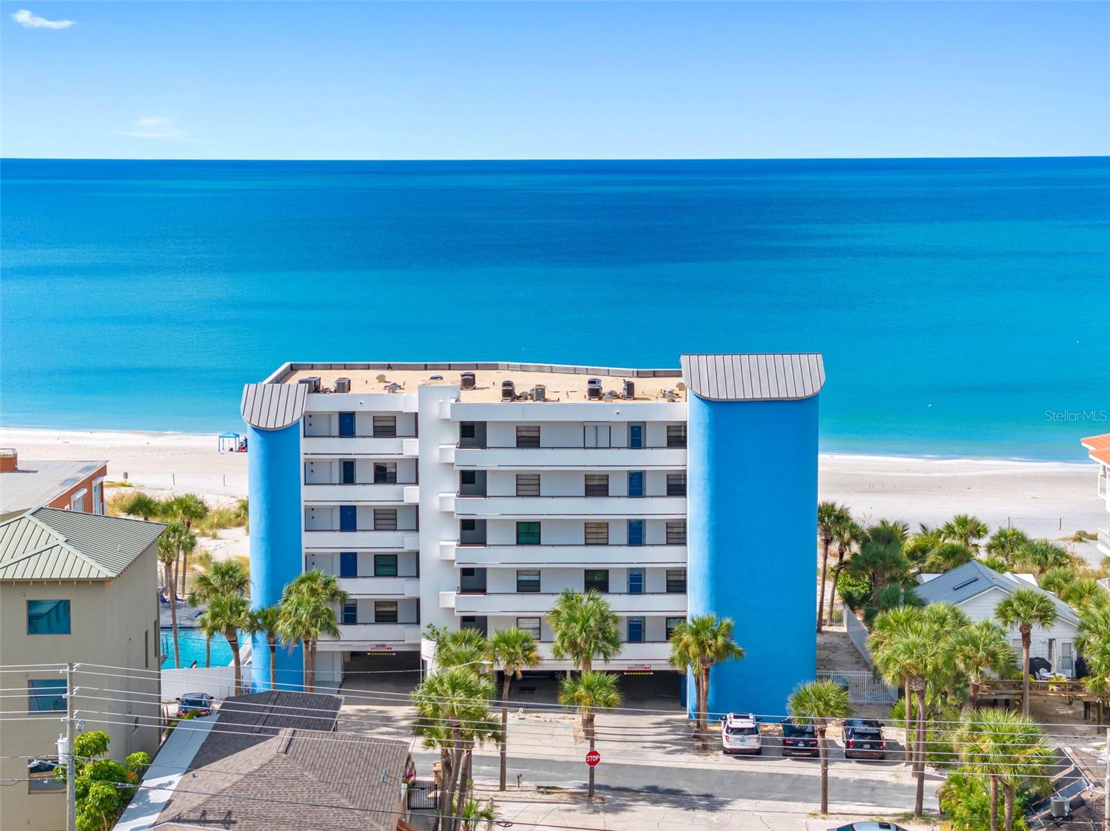 This rare direct beachfront opportunity in the highly sought-after Chambre building in Madeira Beach offers the perfect blend of coastal luxury and everyday convenience. A wonderful place to experience breathtaking sunsets. This spacious 2-bedroom, 2-bathroom corner unit boasts unobstructed panoramic views of the Gulf of America and the world famous Johns Pass. The thoughtfully designed layout includes a generous primary suite featuring an en-suite bathroom. Each bedroom has a walk-in closet, and convenient access to in-unit laundry. A built-in wet bar adds functionality and charm, making it ideal for entertaining guests while enjoying the stunning beachfront scenery. The kitchen is outfitted with stainless steel appliances, a brushed nickel touchless faucet, and ivory cabinetry, creating a bright, modern space. Throughout the unit, brown fabric roller shades provide both privacy and light control, while brushed nickel hardware on all interior doors adds a cohesive, contemporary finish. A reserved covered parking space under the building is included, paired with tons of guest parking. Easy beach access is enhanced by conveniently located outdoor showers for effortless clean-up after a day by the water. Set back from Gulf Boulevard on the quieter Gulf Lane, the Chambre is a well-maintained, 25-unit community that offers a peaceful and private beachside experience. Residents and guests enjoy an array of amenities, including a heated beachfront swimming pool and spa, a poolside grilling station and shower, a private beachside sun deck, and a secured lobby with elevator access. Ideally located, this property is just a short walk to the vibrant shops and restaurants of John’s Pass Village and within easy reach of local pubs, grocery stores, and convenience shops. Outdoor enthusiasts will appreciate quick access to fishing, boating, paddle boarding, jet skiing, swimming, and kayaking. Centrally positioned, Its about 4 blocks away from world famous Johns Pass Boardwalk , 20 minutes to both Downtown St. Petersburg and Clearwater Beach, and within 45 minutes of Tampa International and St. Pete–Clearwater International Airports. This is a rare chance to own a beachfront residence in one of Madeira Beach’s most desirable communities—perfect for full-time living, or take advantage of 7 day minimum rental period for a beach getaway.