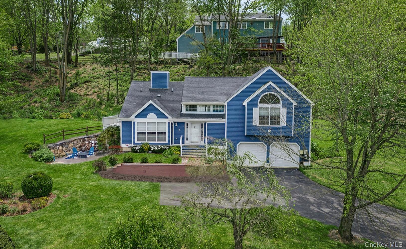 Welcome home to this beautifully maintained contemporary raised ranch nestled on a peaceful street in a sought-after Cortlandt Manor neighborhood. This move-in ready gem offers the perfect blend of comfort and style, where thoughtful craftsmanship meets modern living. Step through the front door and prepare to be impressed by the inviting living room, where soaring vaulted ceilings create an atmosphere of openness and light. Built-in bookshelves frame a cozy fireplace. The eat-in kitchen features a convenient center island and glass doors that seamlessly connect indoor and outdoor living, while the formal dining room awaits your most memorable gatherings. The upper level houses two comfortable bedrooms sharing a well-appointed hall bathroom, plus a generous primary suite boasting vaulted ceilings and a spa-inspired private bathroom that feels like a daily retreat. The walk-out lower level truly shines, offering a spacious family room and a dedicated bar area with direct yard access—perfect for hosting game days or casual get-togethers. Ample storage ensures everything has its place, while the two-car attached garage adds everyday convenience. Freshly painted interiors and gleaming hardwood floors throughout complete this polished package. Location lovers will appreciate proximity to Putnam Valley High School, convenient shopping at nearby grocers, and the natural beauty of Putnam Valley Town Park just minutes away. Metro-North access provides easy commuting options. Schedule your private showing today and discover why this exceptional property deserves to be your next chapter.