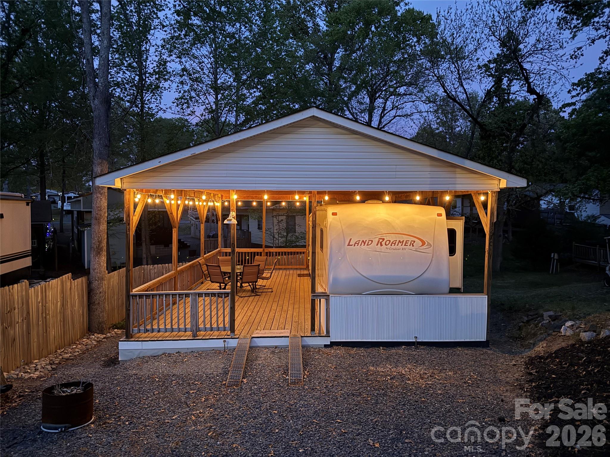 This 30' 2007 Land Roamer by Cruiser RV 5th wheel with 2 slides is ready for summer fun. Nice detail with the bead board work at the end of the camper. Camper couch and dining table both make beds for additional sleeping. King size bed with plenty of walking space and good size storage. Fabulous covered deck with block foundation. This unit can be used like it is or is ready for the addition you like to make it the perfect "Happy Place" for your family.  There is a ramp to park your golf cart on the porch. Roof is approx. 6 years old. Yard Hydrant and metal storage building out back. Everything that is there is included. Oven needs a thermocoupler. All buyers must be with a realtor to gain access to the community.