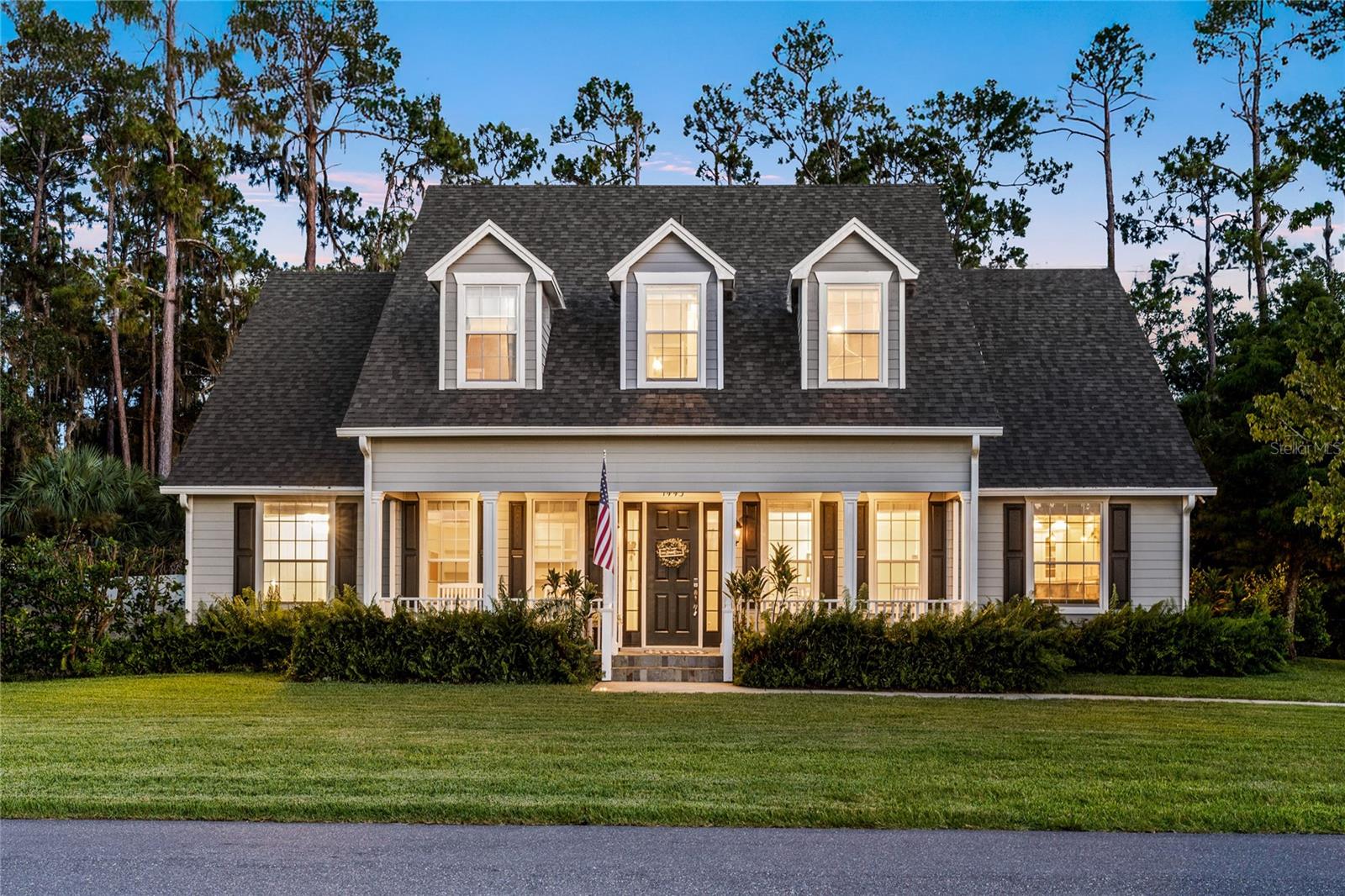 Welcome to this custom-built Cape Cod style estate, offering 5 bedrooms, 4 bathrooms, and a private resort-style pool—perfectly situated in the highly sought-after Stone Island community along the northern shore of Lake Monroe. This one-of-a-kind residence was originally constructed as the builder’s personal home, and it radiates craftsmanship, elegance, and timeless design at every turn.

From the moment you arrive, the home’s stately two-story colonial architecture captures attention with its classic Cape Cod charm. Grand columns, stone accents, shuttered windows, and a wide, inviting rocking chair front porch are nestled beneath a canopy of century-old grandfather oaks. The setting is both idyllic and exclusive, surrounded by natural beauty with private access to the St. Johns River and Intracoastal Waterway via the community’s boat ramp.

Inside, the home delivers a series of breathtaking spaces, starting with a soaring foyer and custom French doors that open into a private office featuring coffered ceilings, built-in shelving, and detailed millwork. Just beyond, the formal dining room offers a warm, intimate setting with hardwood flooring and a charming fireplace.

At the heart of the home lies a dramatic family room with 25-foot ceilings, engineered hardwood floors, a gas fireplace wrapped in stone, and a built-in theater system. The ambiance is enhanced by Juliet balconies above, double island-style ceiling fans, and a whole-home audio system that sets the tone for both entertaining and relaxation.

The chef’s kitchen is a dream come true—lined with white linen cabinetry featuring glass-accented displays, illuminated to highlight the rich contrast of ebony granite countertops. A large center island, two sinks, and stylish pendant lighting complete the elegant, functional space.

The thoughtfully designed layout includes dual staircases leading to separate upstairs wings, where you’ll find spacious secondary bedrooms and a versatile bonus room, ideal for a media area, game room, or private retreat.

The outdoor living space is equally impressive. Step into the screened-in backyard oasis featuring a resort-style heated saltwater pool with a grotto, cascading waterfall, LED lighting, and a covered cabana. A fully equipped summer kitchen makes entertaining a breeze, while the tranquil conservation views ensure privacy and peace. The oversized three-car garage is lined with built-in shelving, and a fenced compound with dual swing gates offers ample room to store your boat or trailer.

The property also features modern efficiency upgrades, including insulated glass windows and exterior doors, foam-insulated attic, private 160-foot-deep irrigation well, whole-home generator, and in-wall pest system. The home has also been recently enhanced with a new roof,  as well as a new pool pump, and sprinkler well pump. A detached shed add to the home’s utility and convenience. Located in the vibrant, amenity-rich Stone Island community, residents enjoy access to a private boat dock, fishing, water skiing, tennis courts, horse stables, and neighborhood events throughout the year. Cruise the island by golf cart and experience one of Central Florida’s most unique and desirable waterfront lifestyles. This remarkable Cape Cod estate is truly one of a kind—blending refined living, thoughtful design, and unmatched location into a home you’ll cherish for years to come.