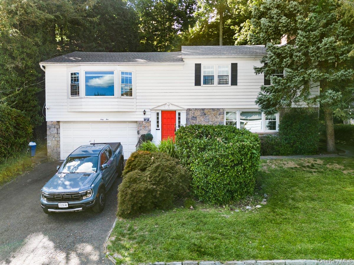 Welcome to this exquisite 3-bedroom, 2-bath raised ranch home tucked away on a picturesque, tree-lined street in the desirable Crestwood enclave of Yonkers. This gorgeous home offers the perfect balance of suburban tranquility and modern elegance. Step inside to discover a sun-drenched open floor plan featuring a well designed Chef’s Kitchen featuring premium finishes and seamless flow to the dining area — perfect for culinary enthusiasts and entertainers alike. Natural light floods the space, creating a warm and inviting ambiance perfect for entertaining or everyday living. This home boasts beautiful hardwood flooring throughout with custom crown moldings/trims along with Central Air as well.
The lovely hall bathroom connects directly to the spacious primary bedroom, which features sliding doors that open to an amazing deck. Two additional generously sized bedrooms complete the main floor. The lower level expands your living space with a warm and inviting family room complete with a wood-burning fireplace, a stylish full bathroom, abundant storage, laundry area, and direct access to the garage.  Outside, enjoy your own secluded oasis with a beautifully landscaped yard, a raised patio area with tree-top views, and a sprawling oversized Deck — ideal for relaxing or entertaining guests in every season.  Truly a commuters dream- just minutes to the Crestwood train station, a stone throw from Bronxville village plus easy access to buses, major parkways and shopping centers. This is Crestwood living at its finest — a turnkey home in a prime location, combining peaceful suburban lifestyle with unbeatable proximity to the city.
