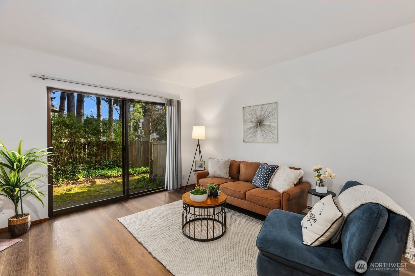 A must see! Welcome yourself home to this beautifully updated end-unit townhome in the desirable Evergreen community of Kenmore. Ideally located just minutes from I-405 and I-5, this home offers an easy commute to both Seattle and the Eastside while maintaining a quiet, tucked-away feel. Thoughtfully refreshed with new flooring, fresh interior paint, and brand-new carpet, the home is truly move-in ready and designed for comfortable everyday living. The functional layout features a bright and open main level, with a spacious living area that flows seamlessly to a private patio with yard space through sliding glass doors—perfect for morning coffee, gardening, pets, or simply relaxing in your own outdoor space. A convenient half bath on the main floor off the living room enhances livability for guests and day-to-day use. Ample kitchen space with bar seating adjacent to the dining nook. Upstairs, you’ll find two well-sized bedrooms and a full bath, offering separation of space and privacy. Dedicated single car detached garage for parking and an exterior storage closet for your day-to-day convenience. One of the best values in Kenmore, this is an incredible opportunity for first-time buyers, investors, or anyone looking to own in a strong Northshore School District location. HOA covers water, sewer, and garbage. A standout option you won't want to miss!