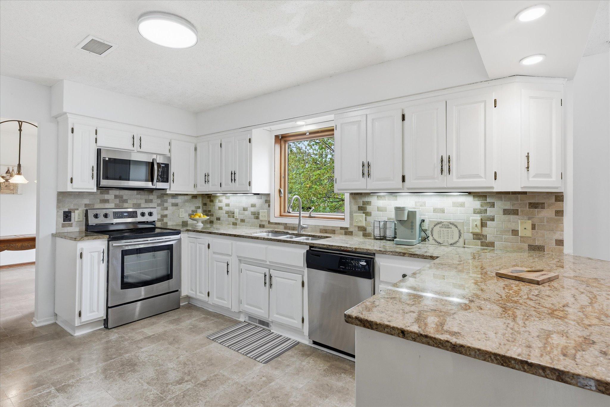 Sitting atop a hill on a quiet cul-de-sac street this well designed 4,000 sq ft custom built home offers an exceptional location, space, and comfort in an established neighborhood, perfect opportunity for multi-generational living.A welcoming front patio sets the tone, leading into a sun filled home- perfect for both everyday living and large scale entertaining. With a large living room, spacious kitchen, three family rooms, two large decks, and a lower level walkout, there’s room for everyone to spread out and enjoy.At the heart of the home is a sunken family room located just off the kitchen with a dramatic floor to ceiling brick fireplace, creating a warm focal point for gatherings. The layout includes four bedrooms, with three on one level, plus a huge combo mud/main level laundry room for added ease and storage.The primary suite is a true retreat, featuring heated floors, a separate tub and shower, and a walk in closet with a window that fills the space with natural light.Outside, the home continues to impress with a beautiful yard, a 3 1/2  car garage, hardy board siding, and a full sprinkler system for easy maintenance. Surrounded by mature trees and just minutes from restaurants, parks, and shopping, this home is ready to welcome its next owner.
