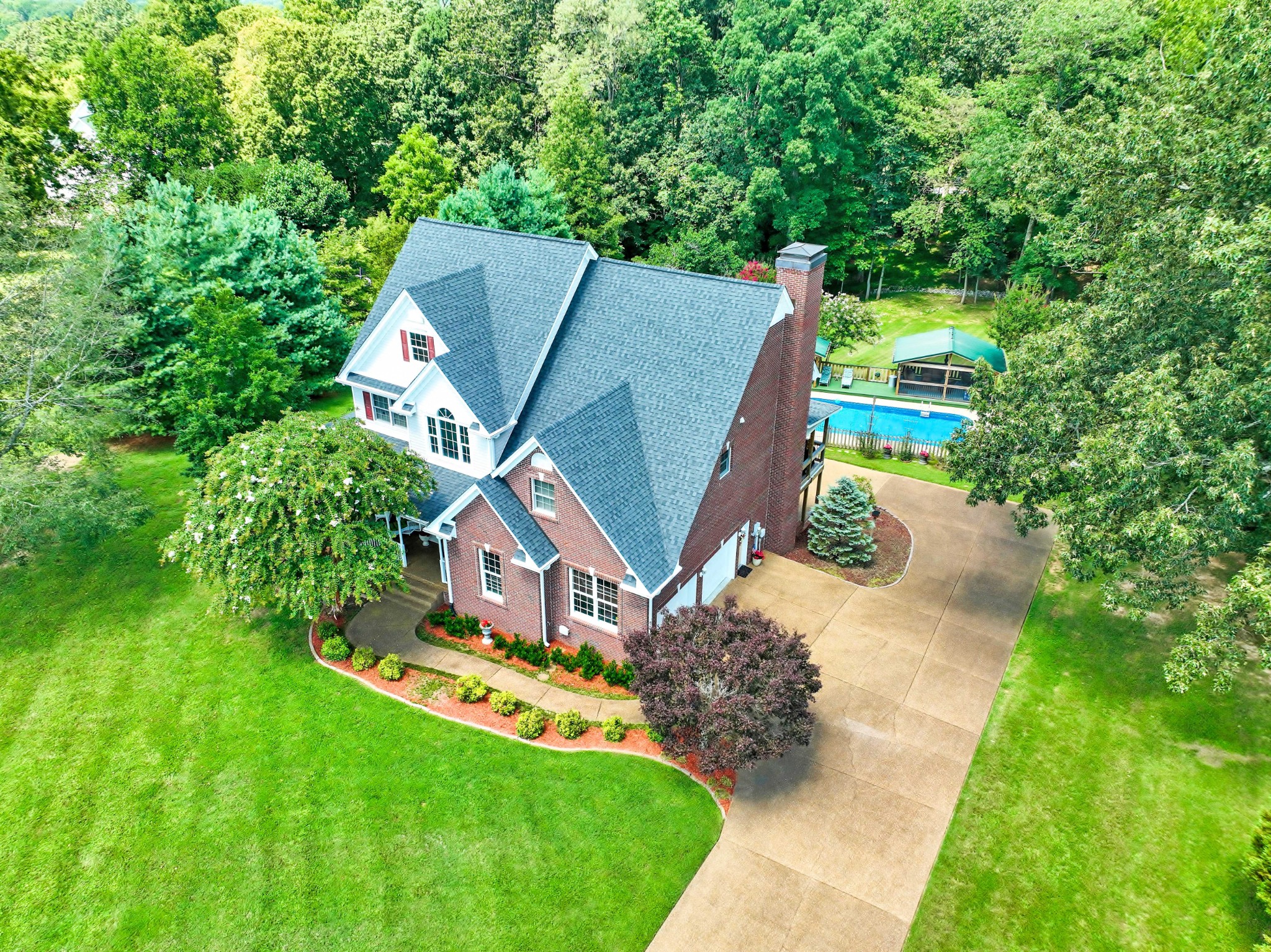 Meticulously maintained home on 2+ acres, only 2 miles from I-24 & NO HOA! This 3,206 sq. ft. home offers plenty of space & versatility for all! Featuring an 18’ x 36’, 8 1/2‘ deep pool, covered deck & open patio for relaxing or entertaining, plus a screened palapa in the back; a charming wrap-around front porch & a driveway that enters both main level & basement garages; Enter the grand foyer with 2 closets & hardwood floor which leads to the lovely kitchen with quartz counter & back splash, double ovens, a gas cooktop, island, stainless steel appliances and a seamless flow into the spacious den, adorned with a cozy gas fireplace. Step outside onto the covered deck, an ideal extension of the home, to enjoy the fresh air in the evening, drink morning coffee while watching the wildlife & the private view of the woods; a tremendous primary suite features a 18’ x 19’ bedroom with built-ins, 12’x13’ walk-in closet, upgraded bath with free standing claw foot tub, tiled shower & his/hers vanities; there’s 3 large guest rooms & a Jack & Jill bath; the full basement has an 11 ft. + tall ceiling, a half bath, tons of storage, garage & storm shelter area; at the end of the day - a hot tub provides a comforting place to unwind; Don’t miss this wonderful home!