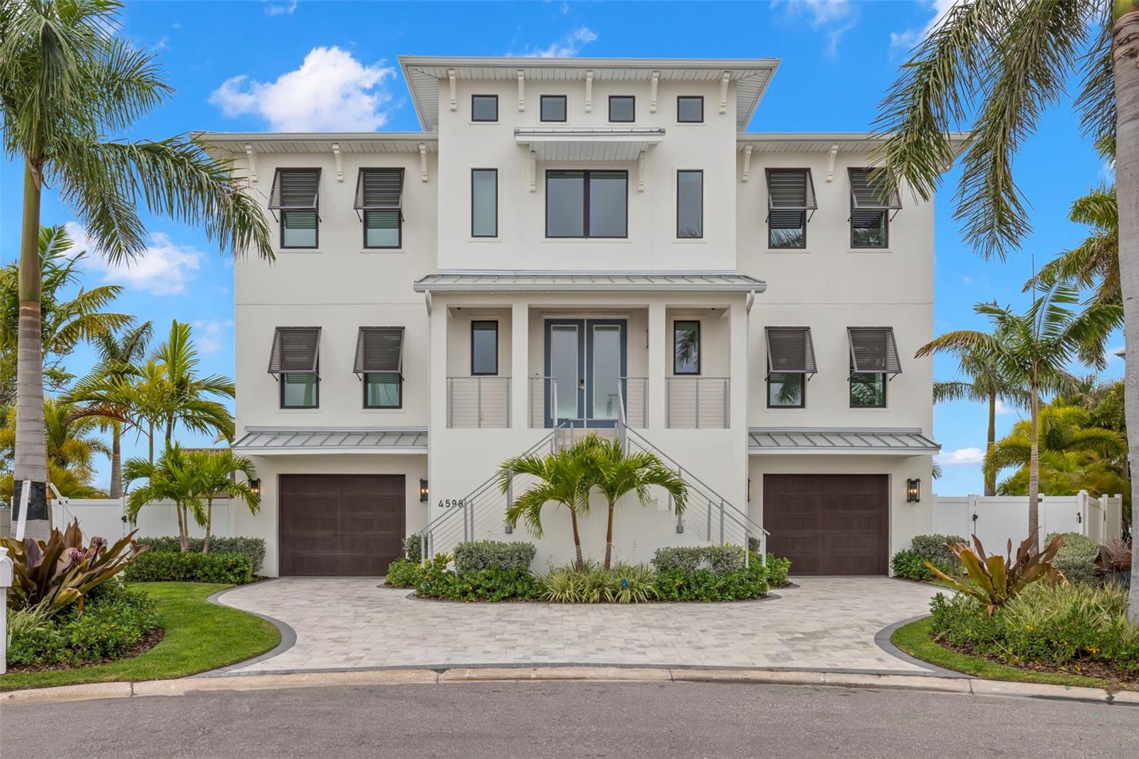 Perfectly positioned at the end of a quiet cul-de-sac, this exceptional coastal contemporary estate offers 160 feet of west-facing waterfront, panoramic views, abundant natural light, and deep-water access to the Intracoastal Waterway and the Gulf of America. Built in 2023 with a focus on modern luxury and effortless coastal living, this remarkable residence features 5 bedrooms,3.5 bathrooms, an oversized 4-car garage, and a private gym. A dramatic double-door entry opens to a grand foyer with a striking modern staircase, soaring ceilings, and walls of glass that frame spectacular waterfront views throughout the home. Rich white oak flooring, exquisite custom millwork, and sophisticated designer finishes create an elegant yet inviting atmosphere. At the heart of the home, the spectacular chef's kitchen features a statement island, professional-grade appliances, custom cabinetry, walk-in pantry, and designer lighting. The kitchen flows seamlessly into the expansive family room and out to a massive waterfront balcony, complete with an outdoor kitchen and beautifully finished wood ceiling—an exceptional setting for entertaining while taking in panoramic water views and unforgettable sunsets. The luxurious primary suite is a private waterfront sanctuary with sweeping water views, dual walk-in closets, and a spa-inspired  bath featuring dual vanities, a soaking tub, and an oversized walk-in shower. Additional bedrooms are generously proportioned and filled with natural light and beautiful water views. Outdoor living is equally impressive. Multiple terraces provide exceptional spaces for entertaining and relaxation, while the resort-style pool with spa, and bubblers creates a private oasis overlooking the water. A newer seawall and 50ft new Trex dock complete with 24k lb boat lift provide excellent deep-water access and effortless boating to the Intracoastal Waterway and Gulf. From its exceptional construction and sophisticated interiors to its expansive waterfront, private dock, resort-style pool, and spectacular western sunsets, this one-of-a-kind estate represents a rare opportunity to experience the very best of Gulf Coast waterfront living.